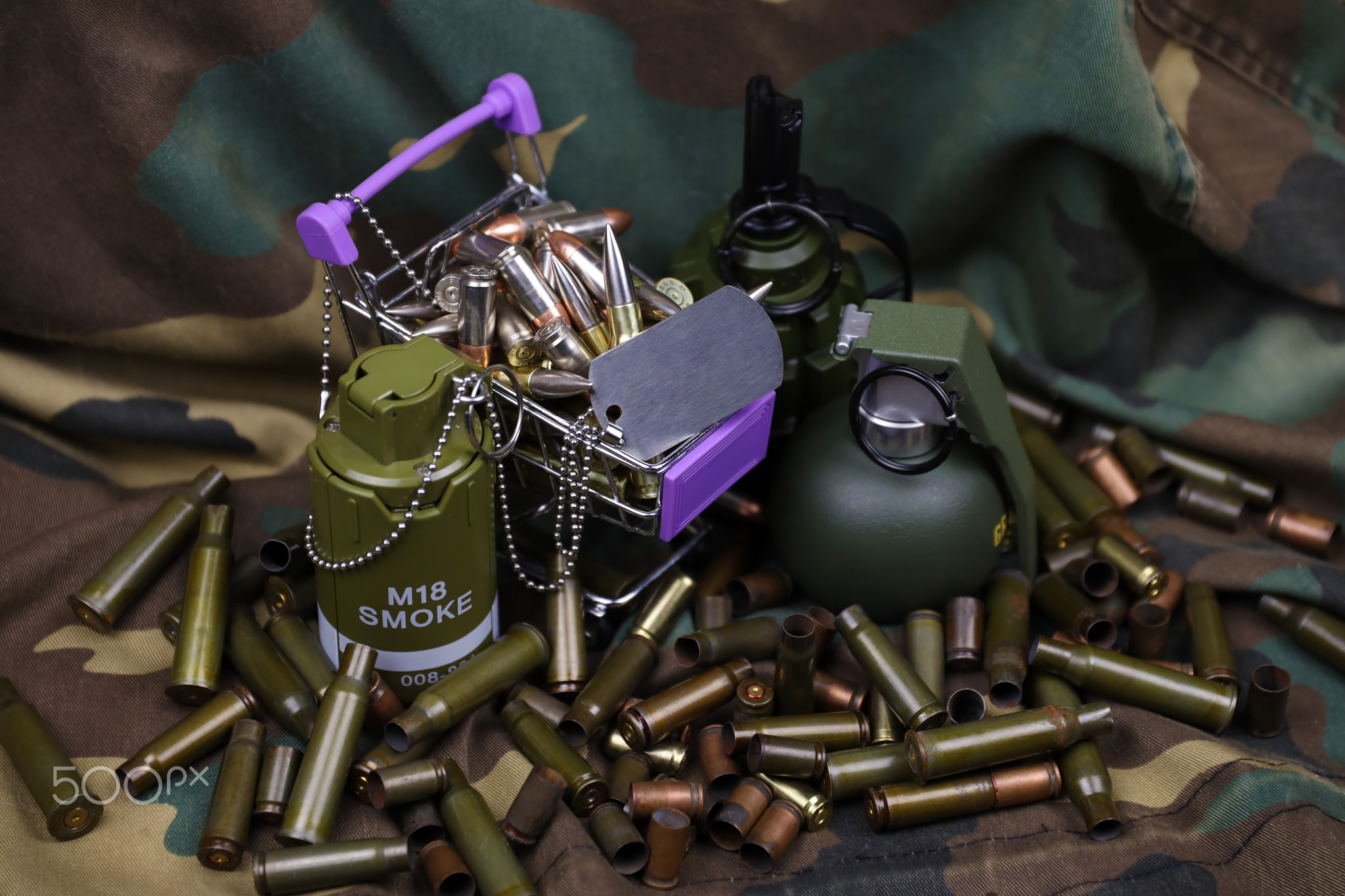 Rifle cartridges in small shopping cart. Big caliber ammo cartridges and hand grenades with a small