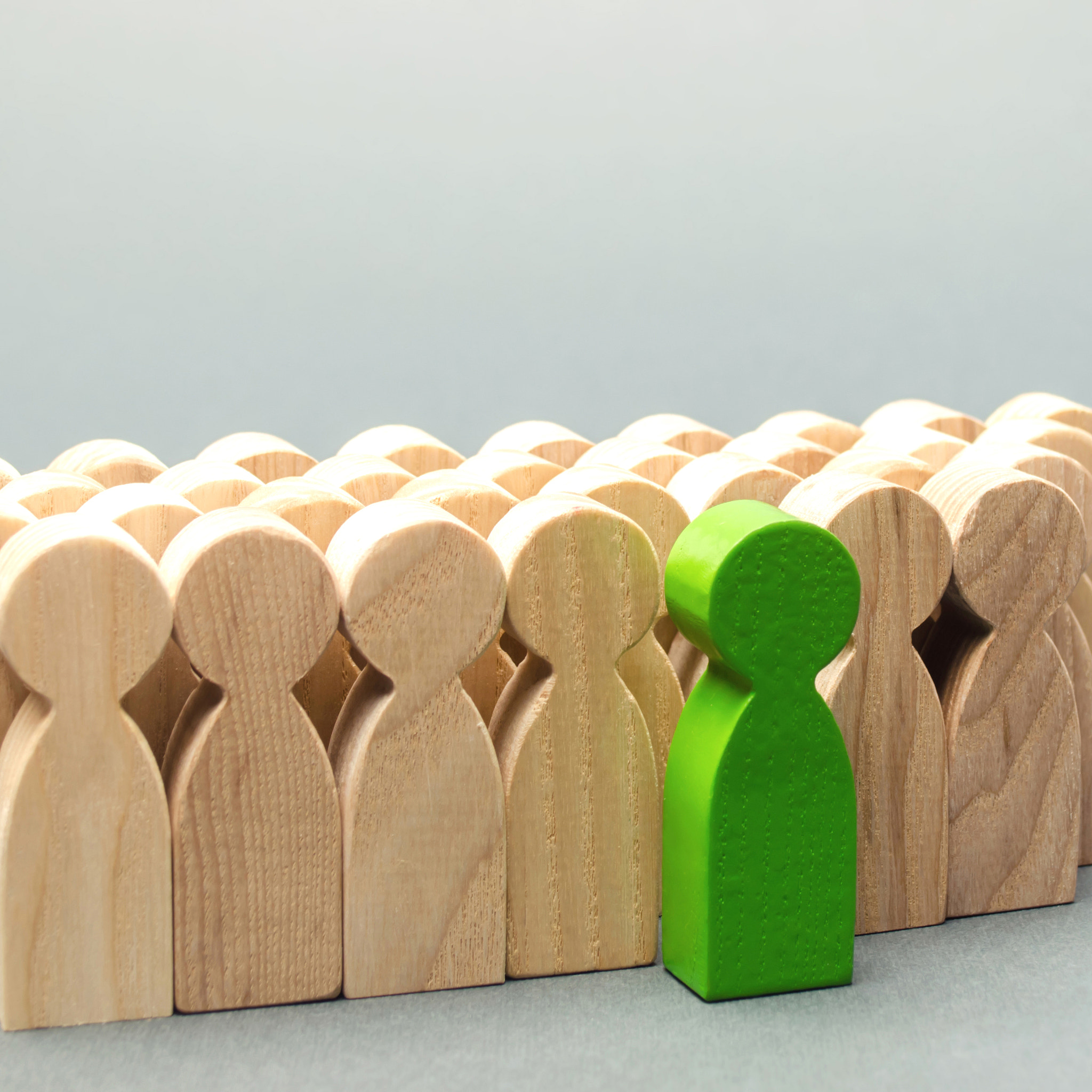 Green man coming out of the crowd. The chosen person among others. A talented worker. Promotion. Con