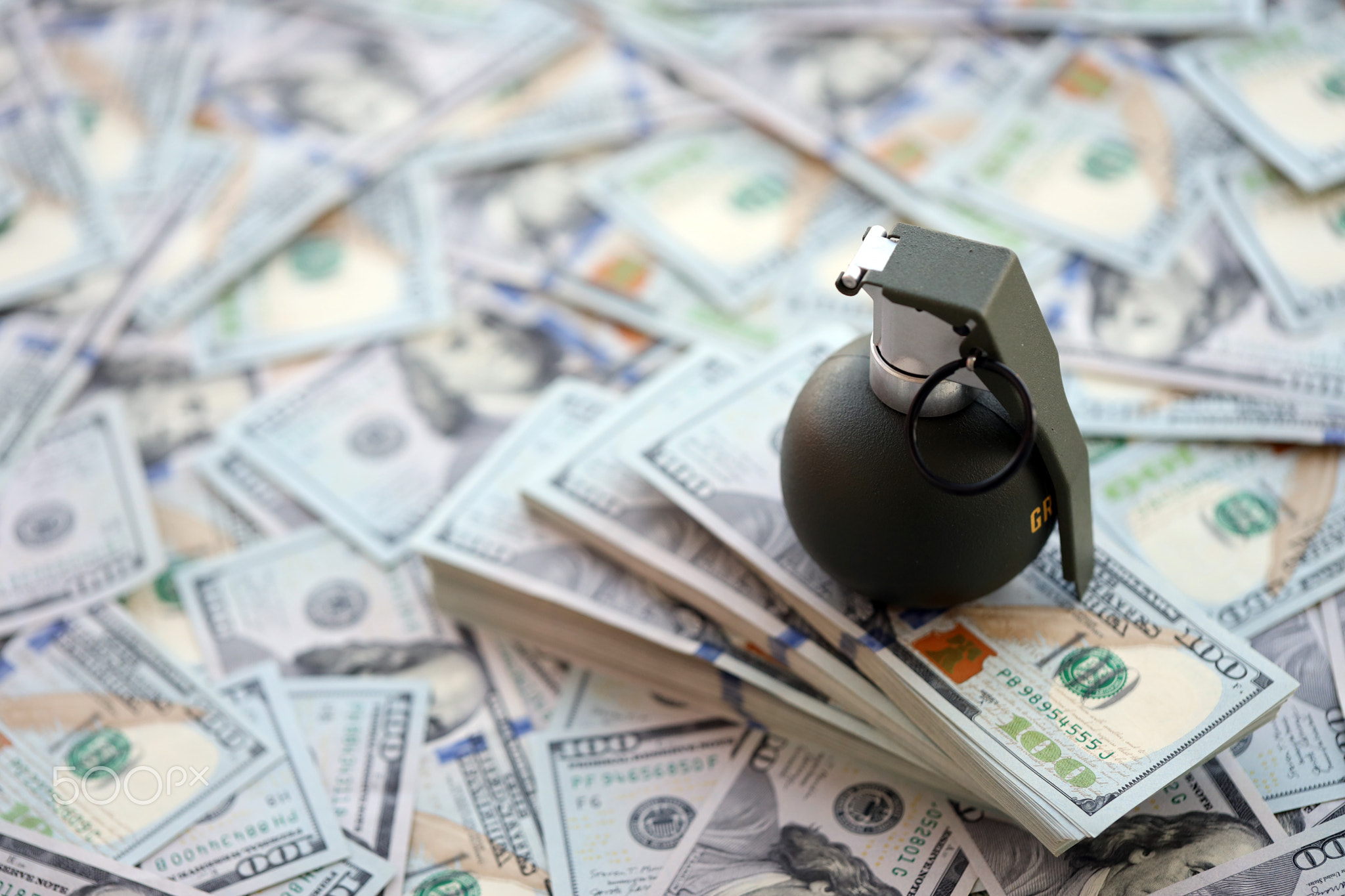 Grenade with a check against the background of huge amount of american dollar bills