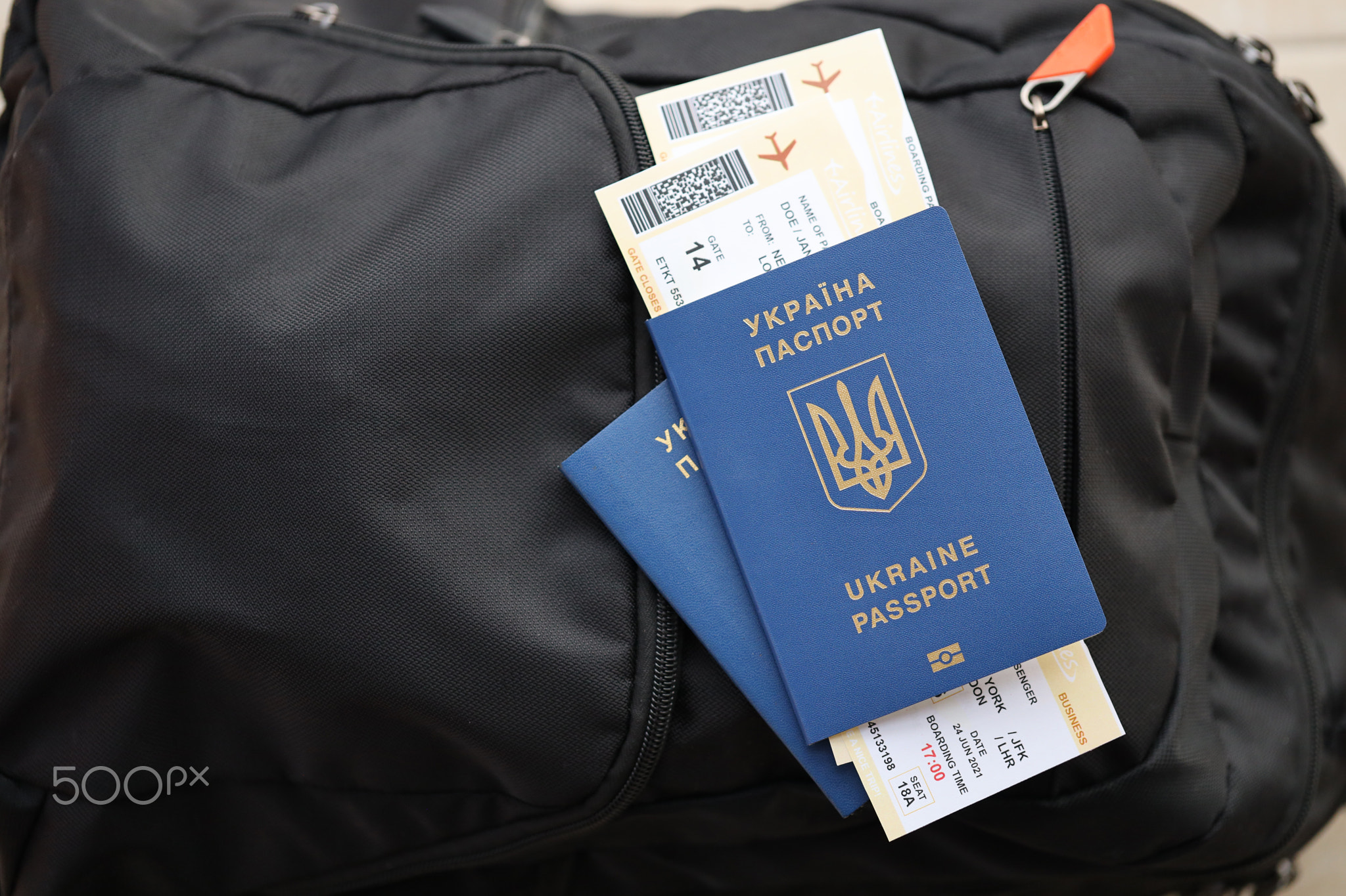 Two ukrainian biometrical passports with air flight tickets on black touristic backpack