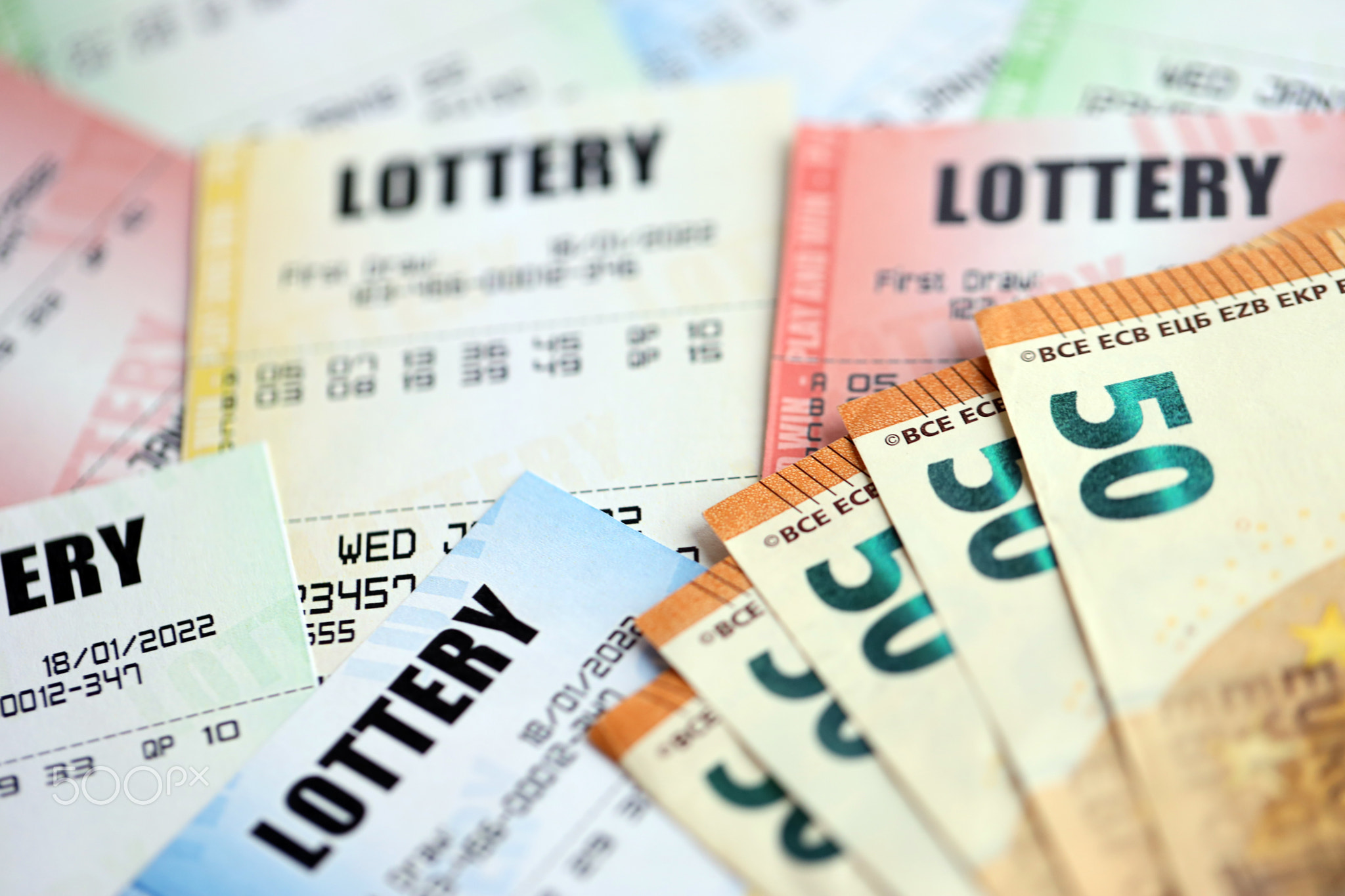 Many lottery tickets and euro bills on blank bills with numbers for playing lottery