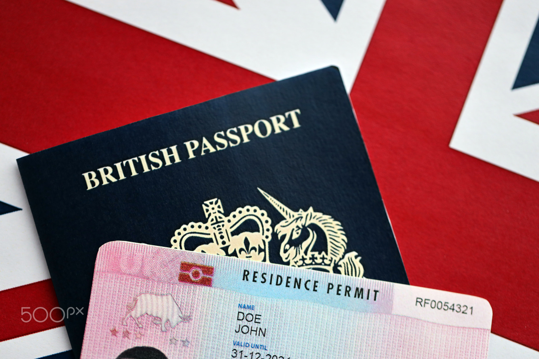 Residence Permit BRP card and British Passport of United Kingdom on Union Jack flag