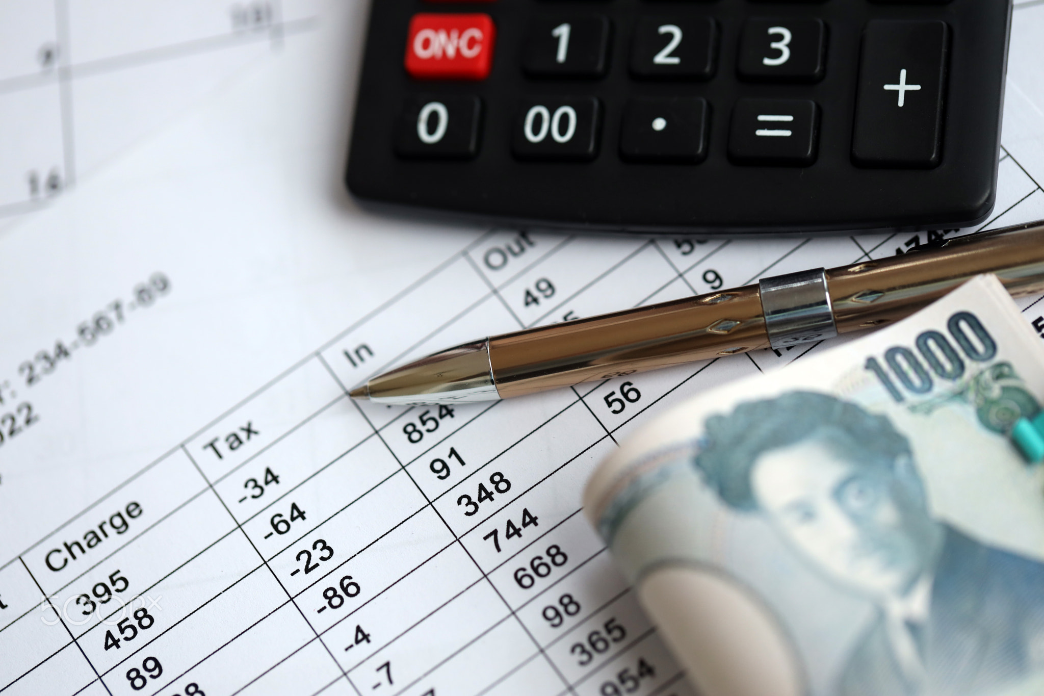 Japanese tax calculations lies on table with calculator, pen and japanese yen money bills