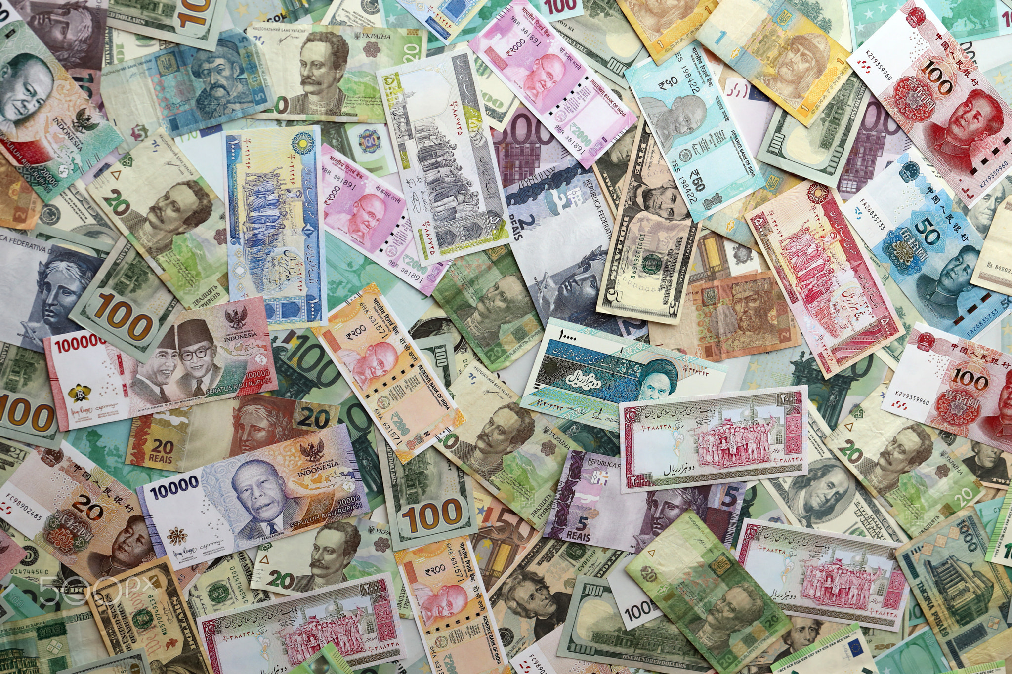 Many banknotes of different currency. Background of big amount of random money bills