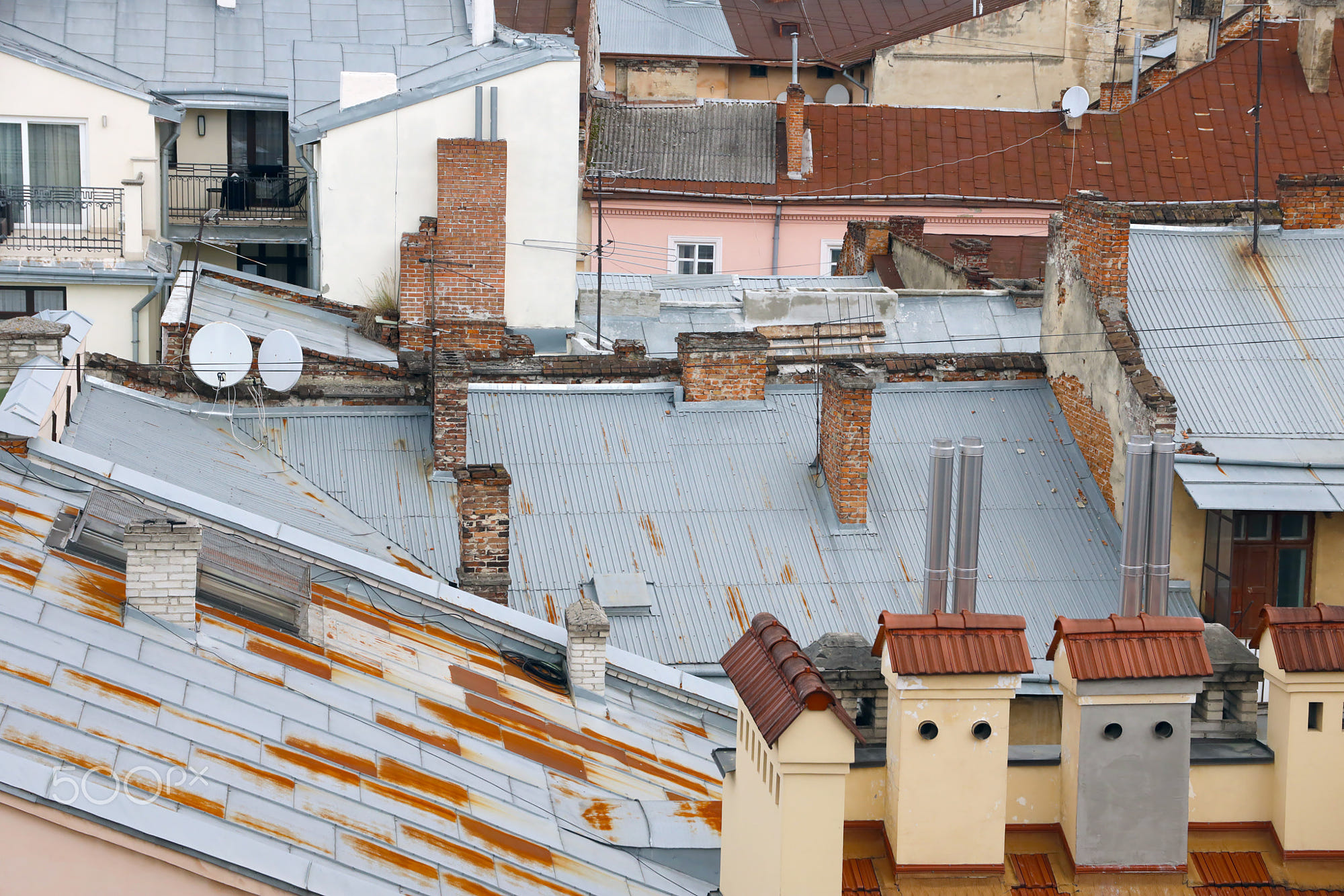 View of roofs of historical Old city of Lviv, Ukraine: View of the roofs of historical Old city of Lviv in Ukraine. Church towers and many rusty shingled roofs in the background