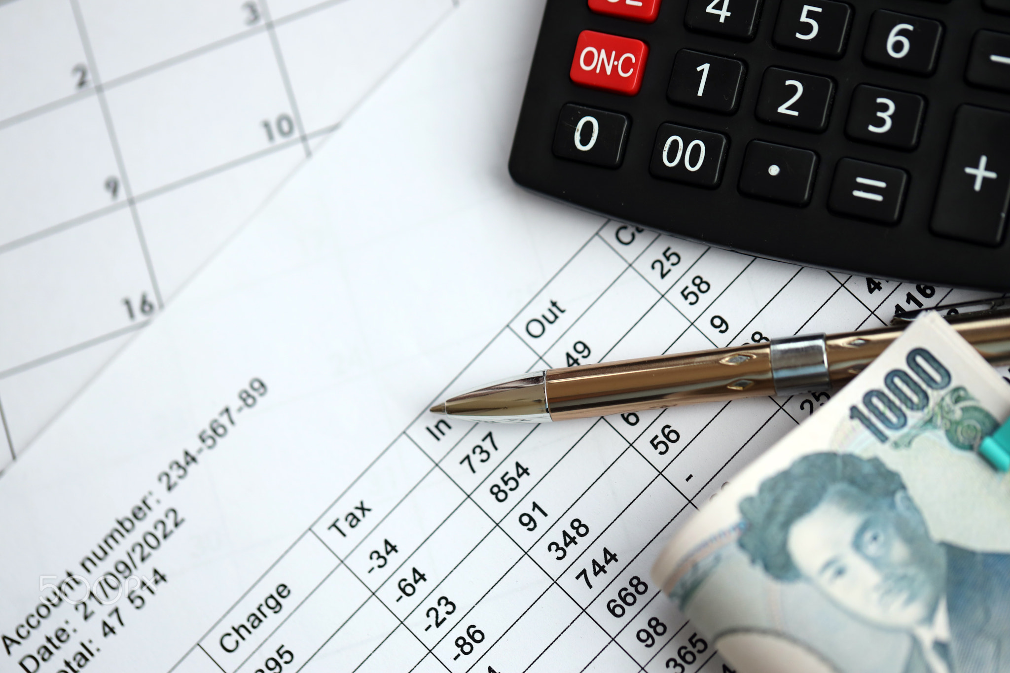 Japanese tax calculations lies on table with calculator, pen and japanese yen money bills