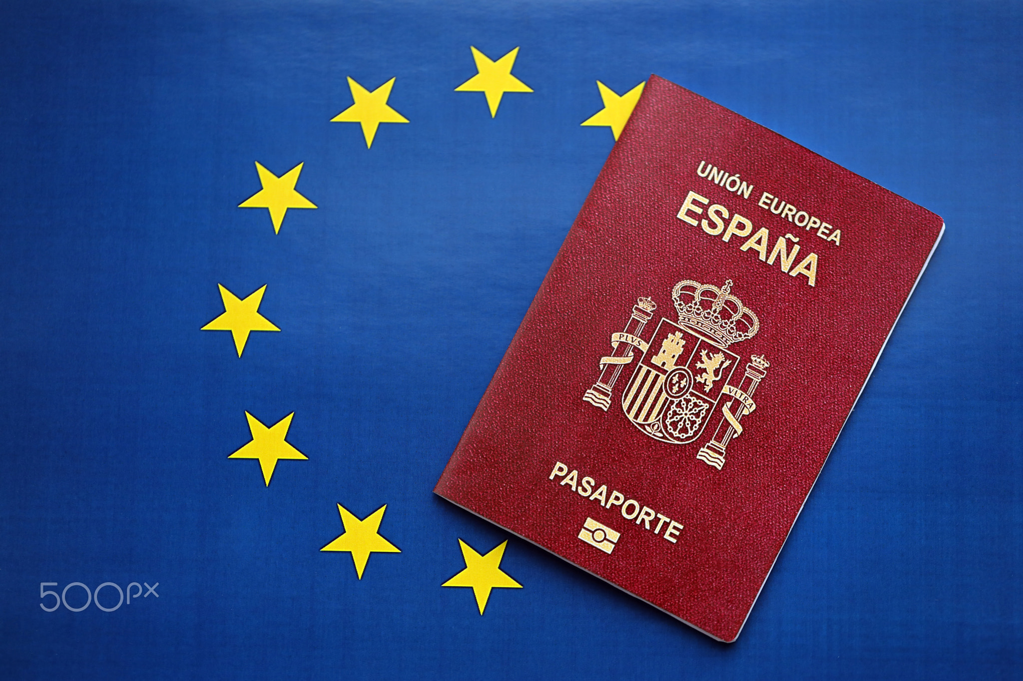 Red Spanish passport of European Union on blue flag background close up