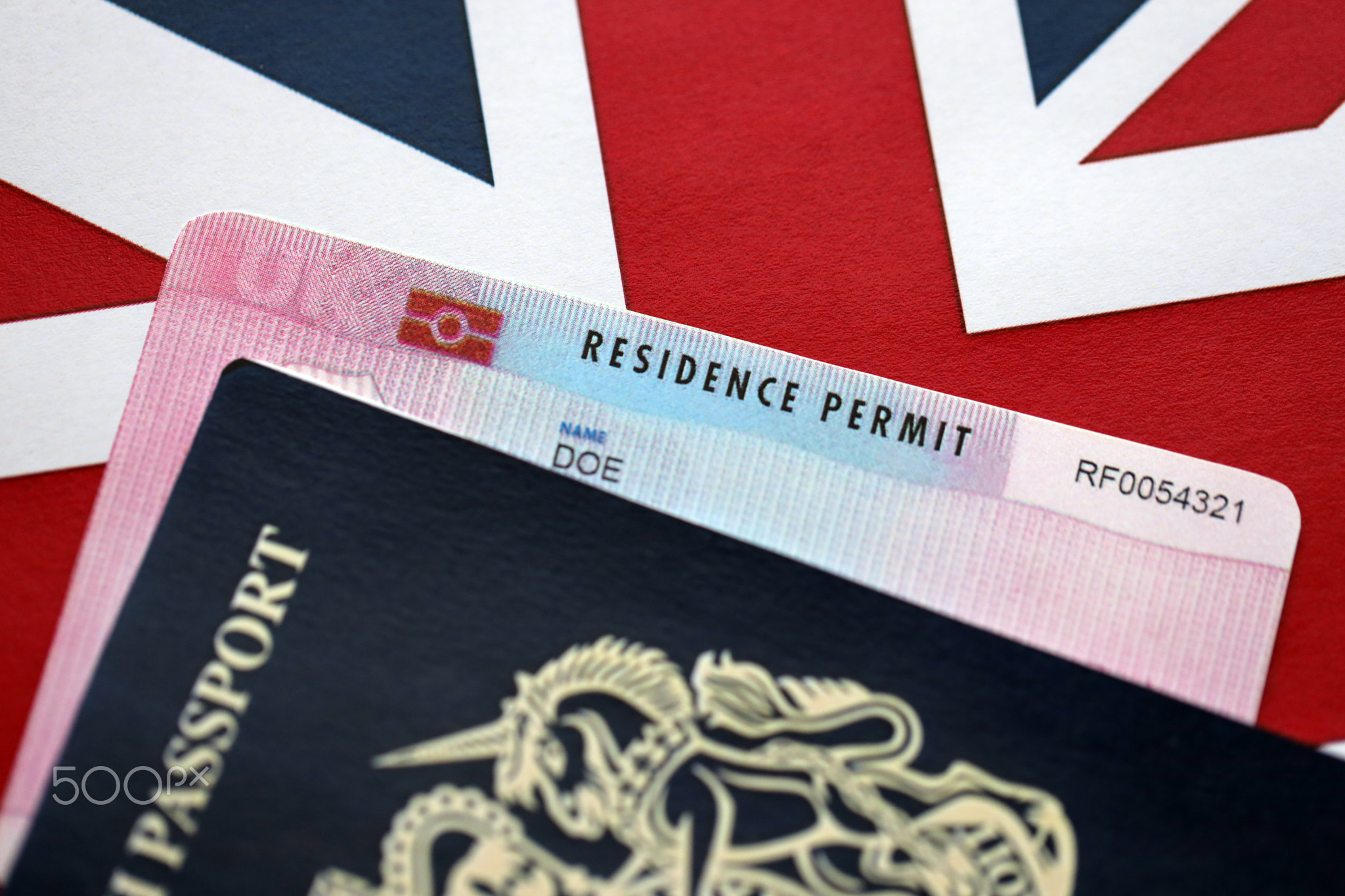 Residence Permit BRP card and British Passport of United Kingdom on Union Jack flag