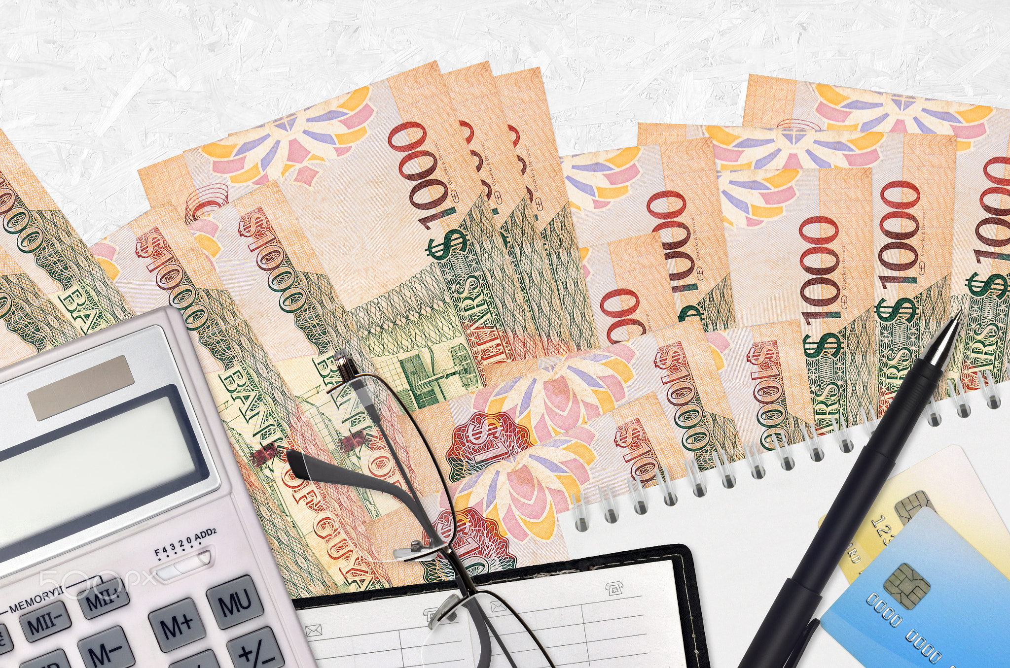 1000 Guyanese dollars bills and calculator with glasses and pen. Tax payment concept or investment