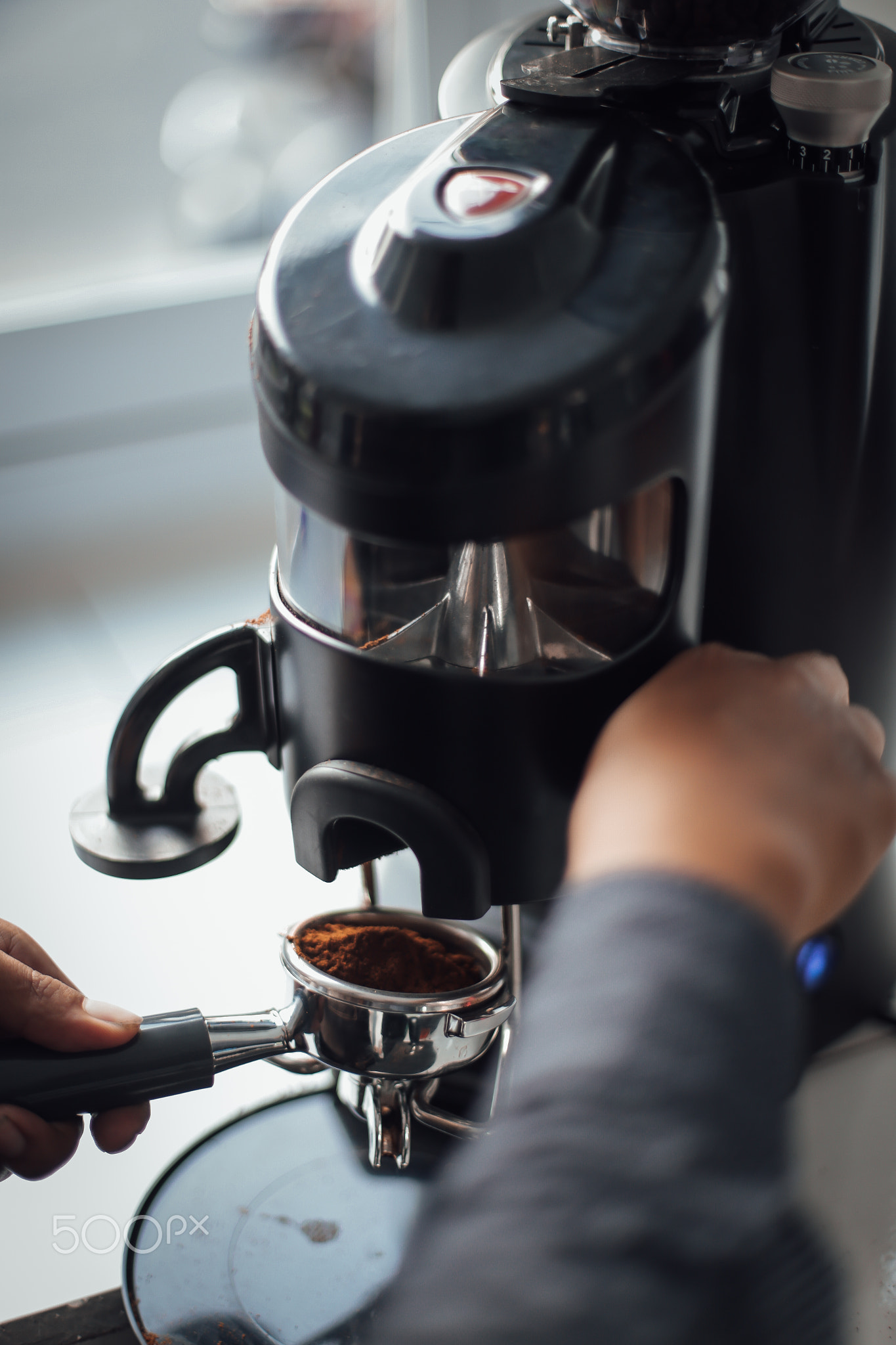 Cropped hands of barista making coffee in cafe