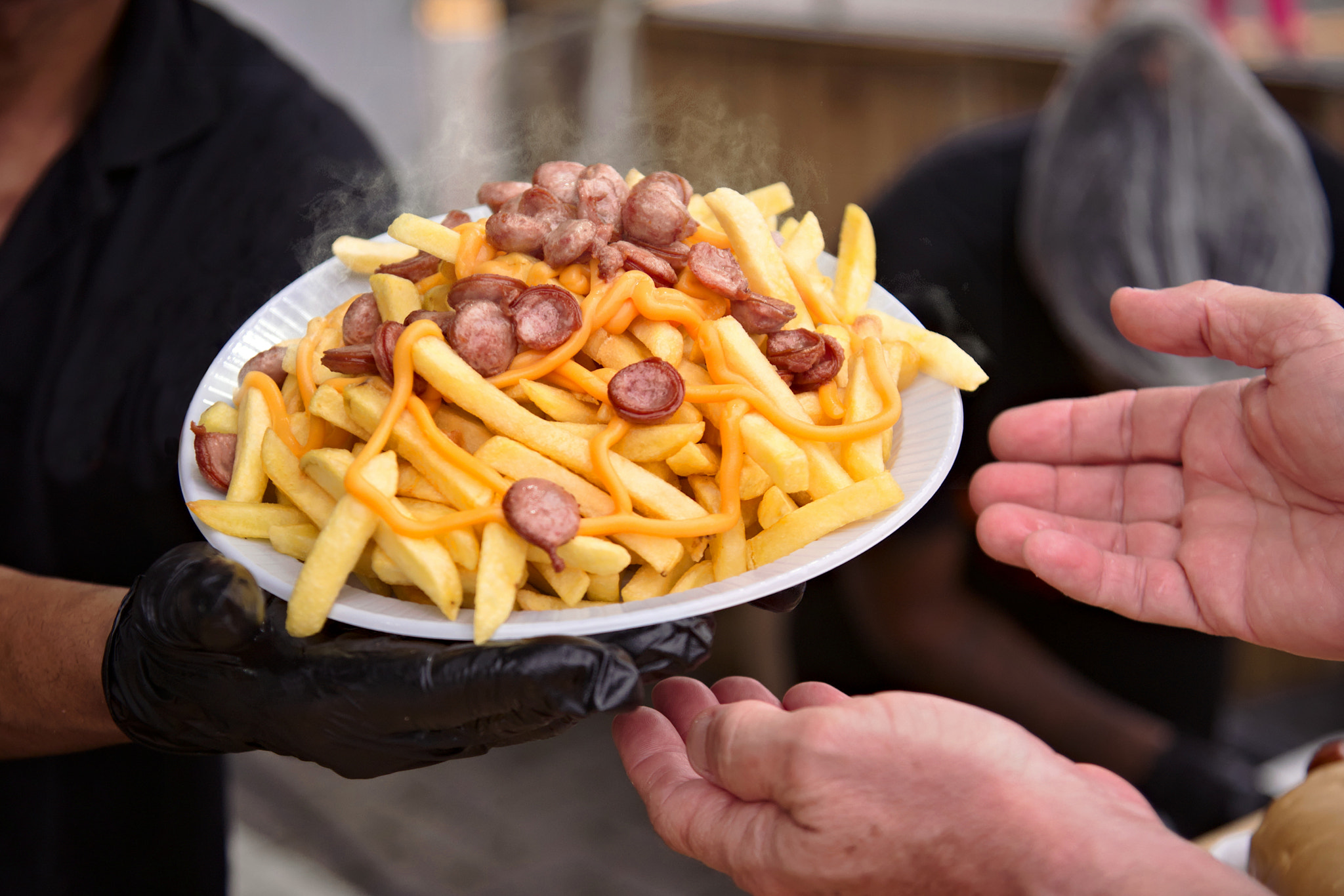 French fries with chopped sausage being served. Very common street food in Rio de Janeiro