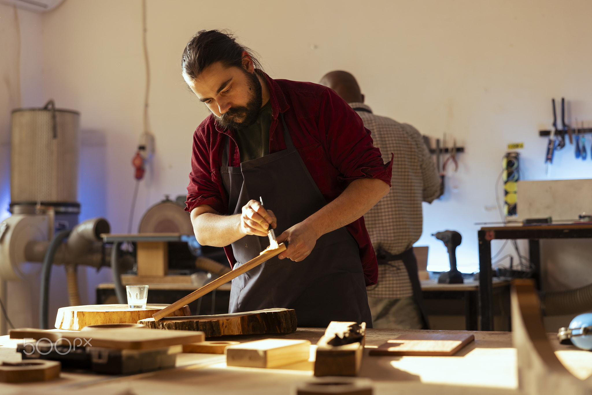 Carpenter brushing varnish on wood to build up protective layer