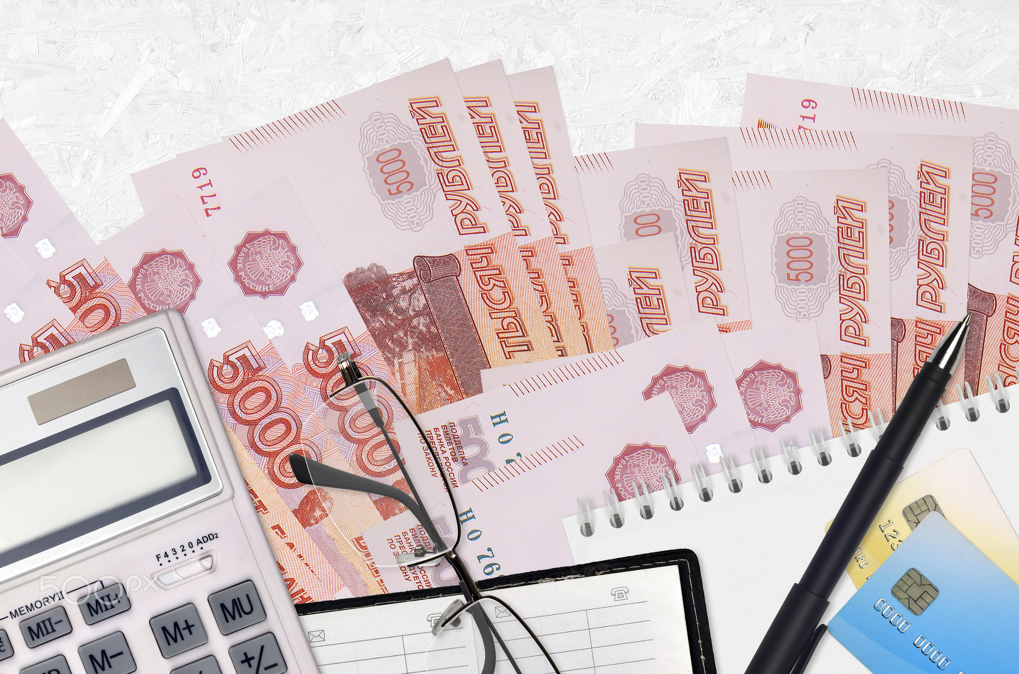 5000 russian rubles bills and calculator with glasses and pen. Tax payment concept or investment