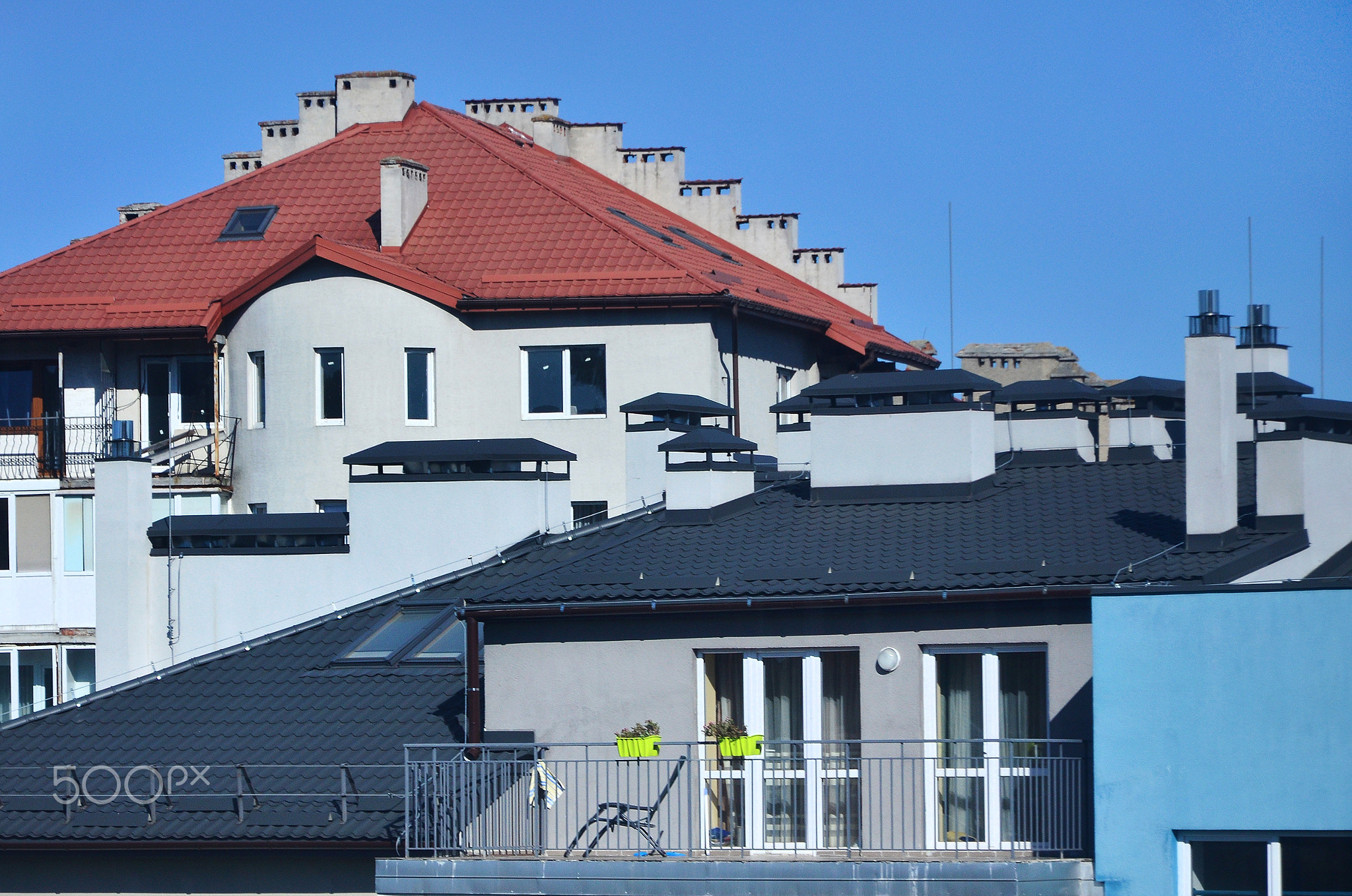 Roofs of modern houses under a cloudless sky. Metal roofing method