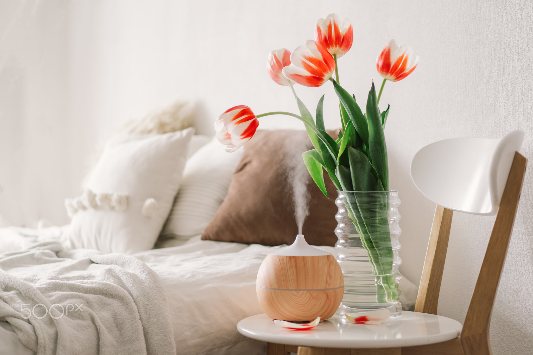 Aromatherapy Concept. Aroma oil diffuser on chair against in the bedroom. Air freshener.