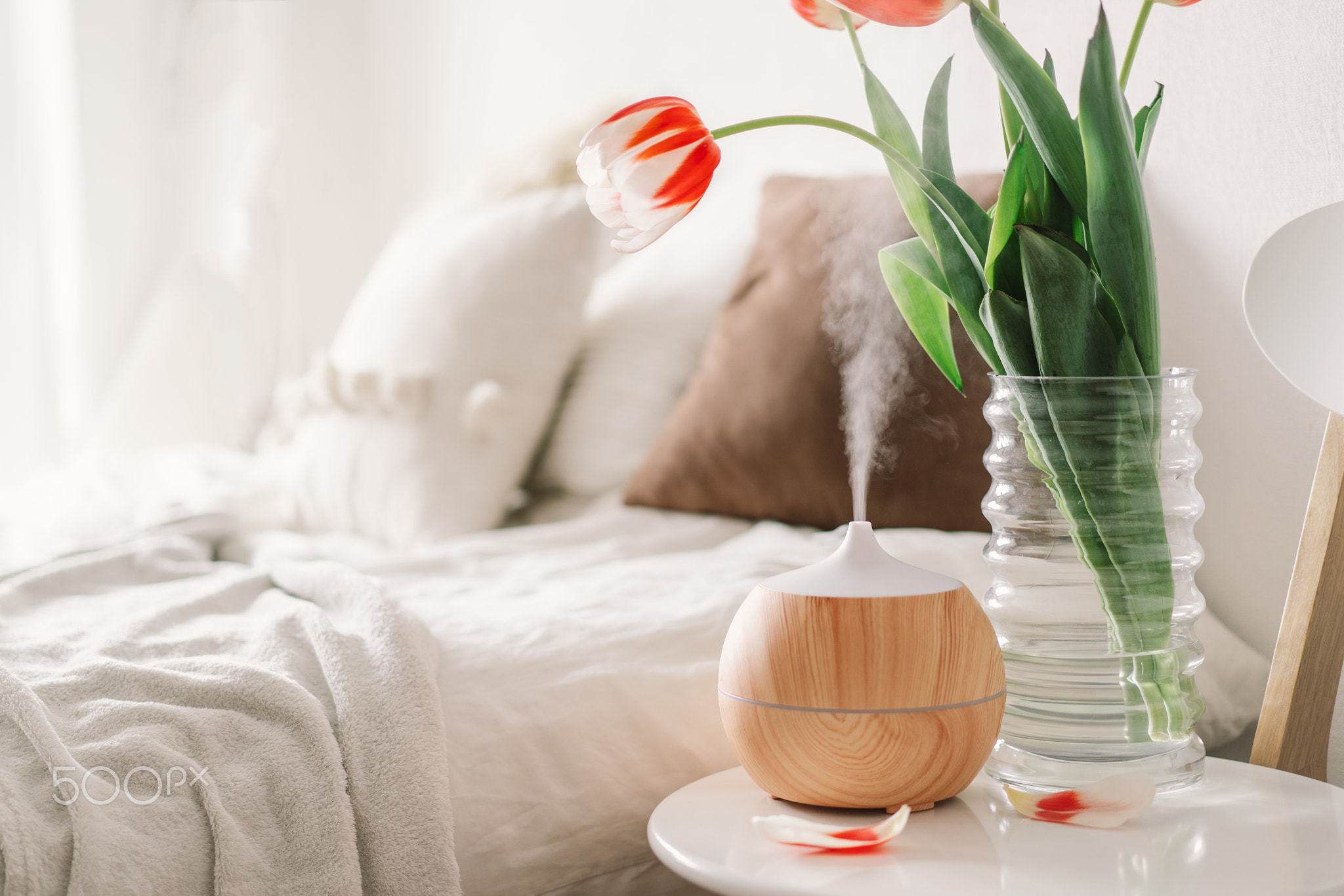 Aromatherapy Concept. Aroma oil diffuser on chair against in the bedroom. Air freshener.
