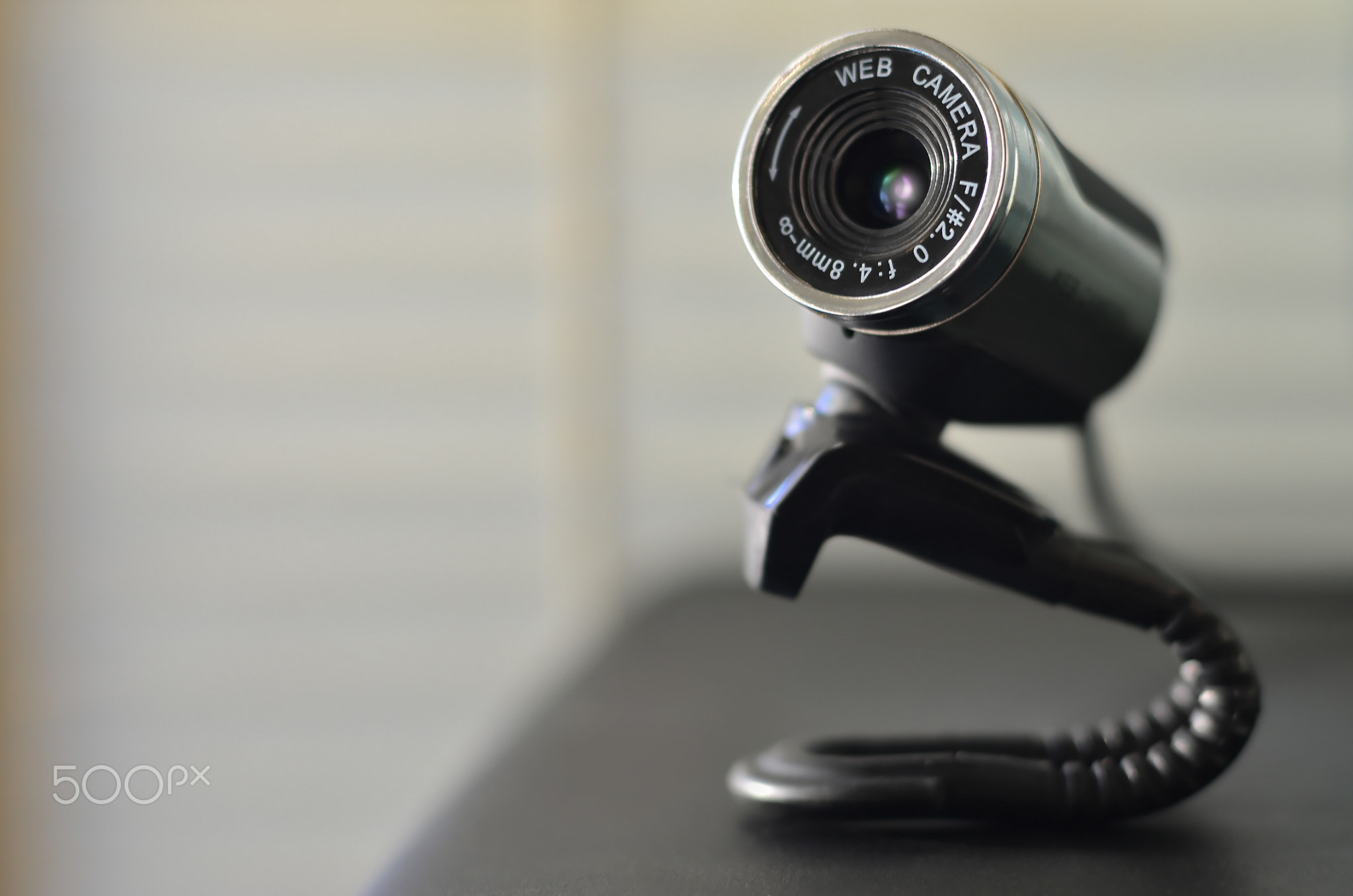 Wired web camera lying on the computer surface. Close up view