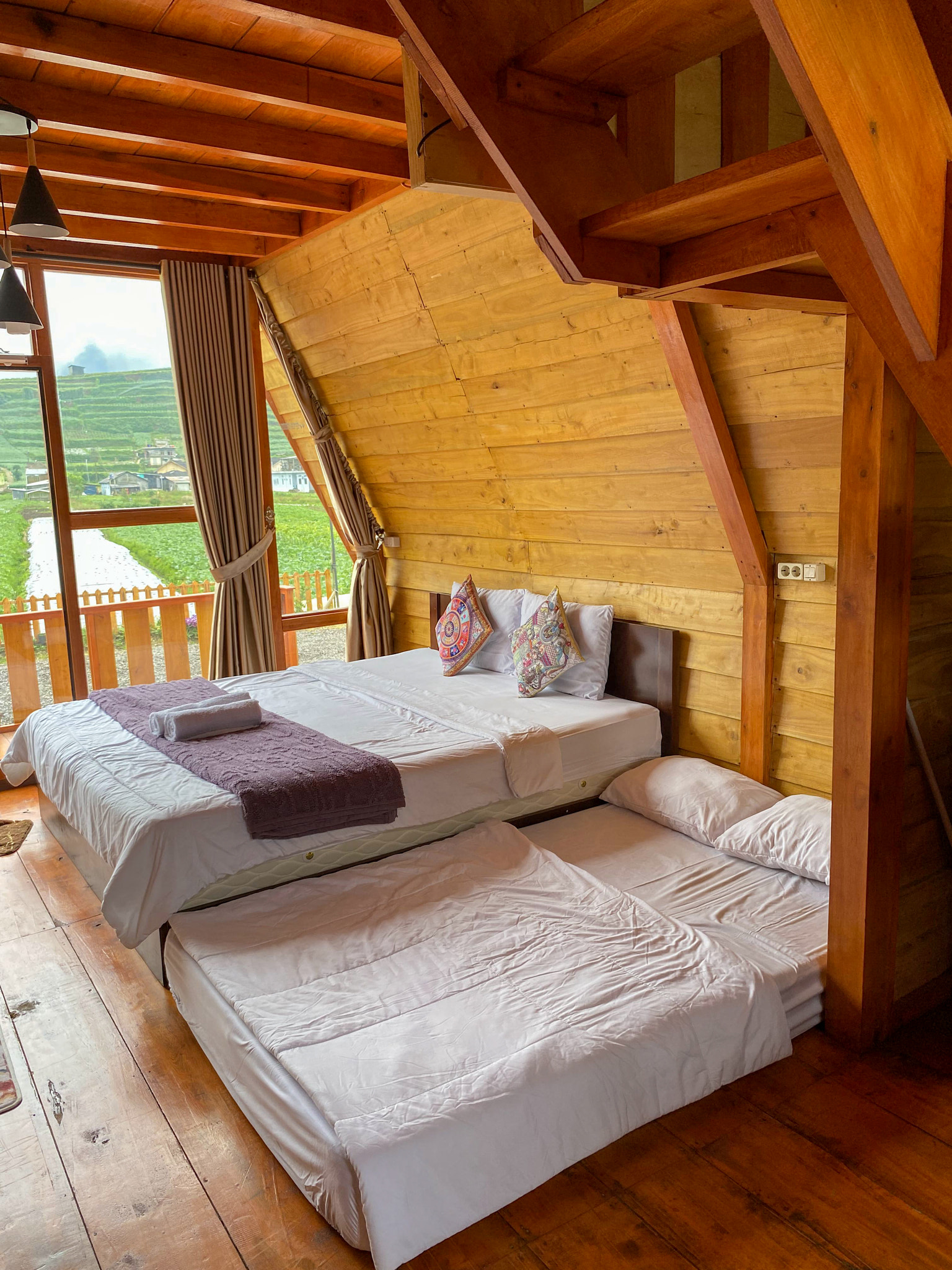 there are two beds in a room with a wooden ceiling