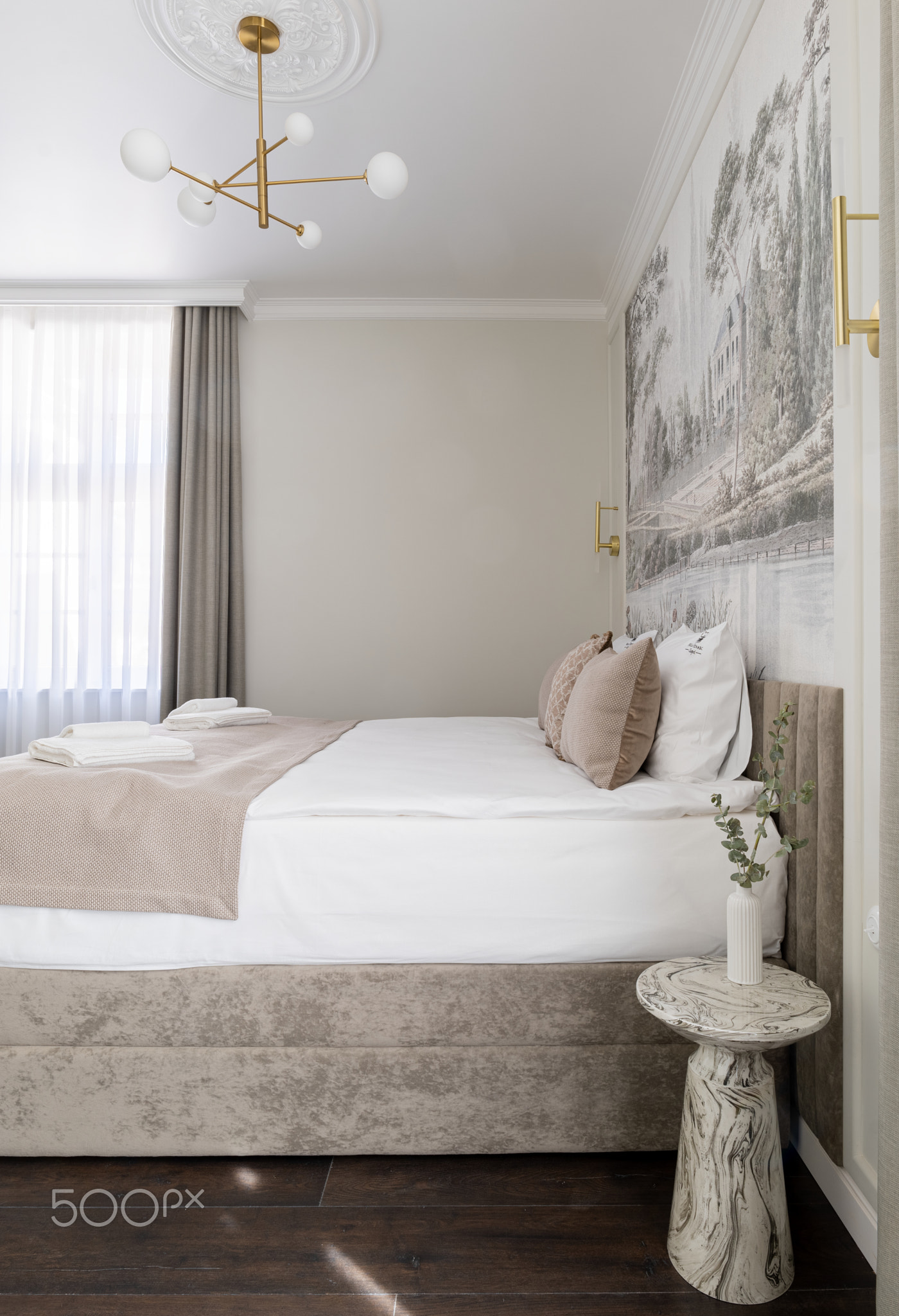 Bedroom furnished with a bed, nightstand, and chandelier for comfort and style