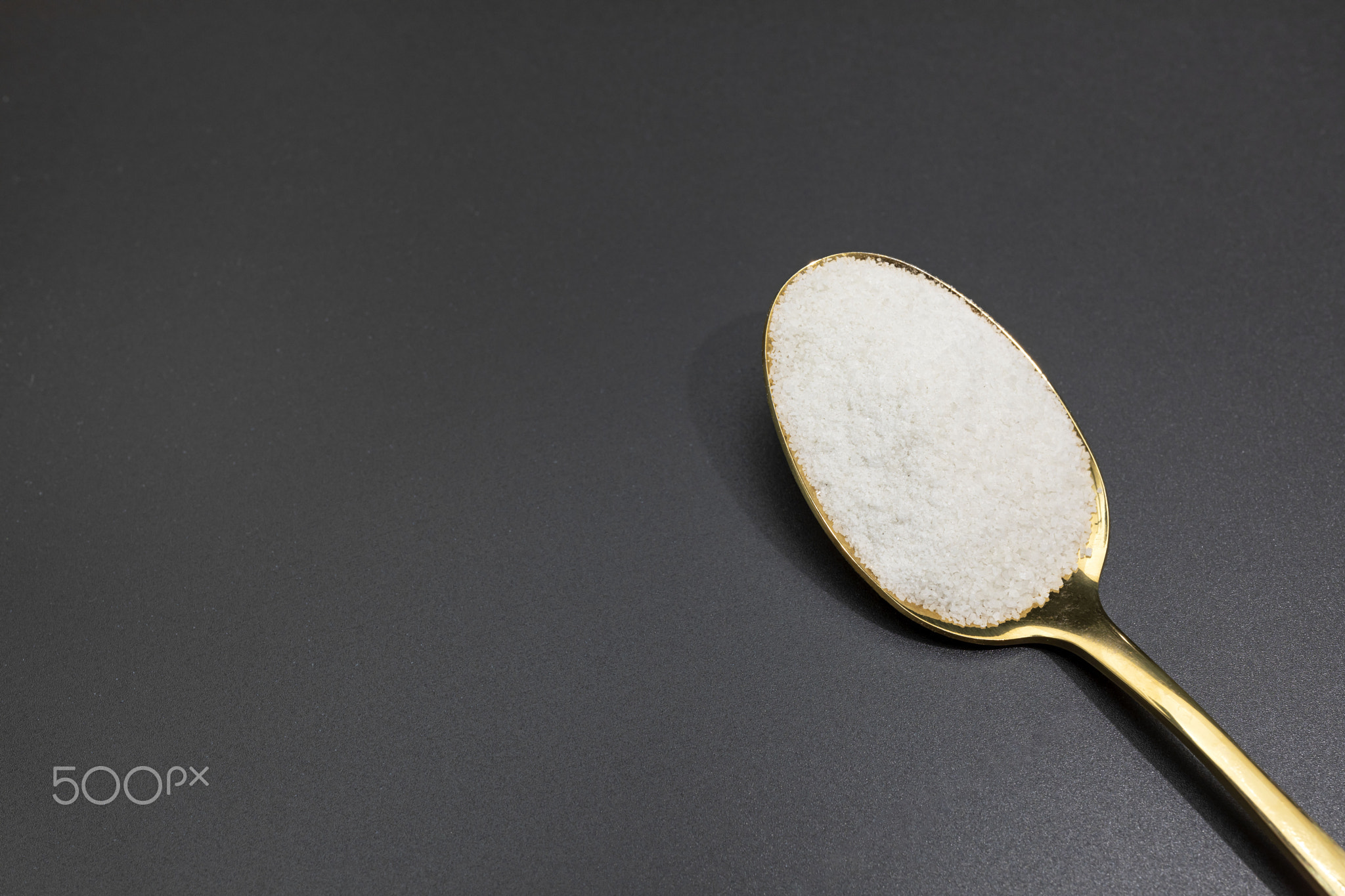 Design Celtic Gray Sea Salt In Golden Spoon on Dark Table, Copy Space