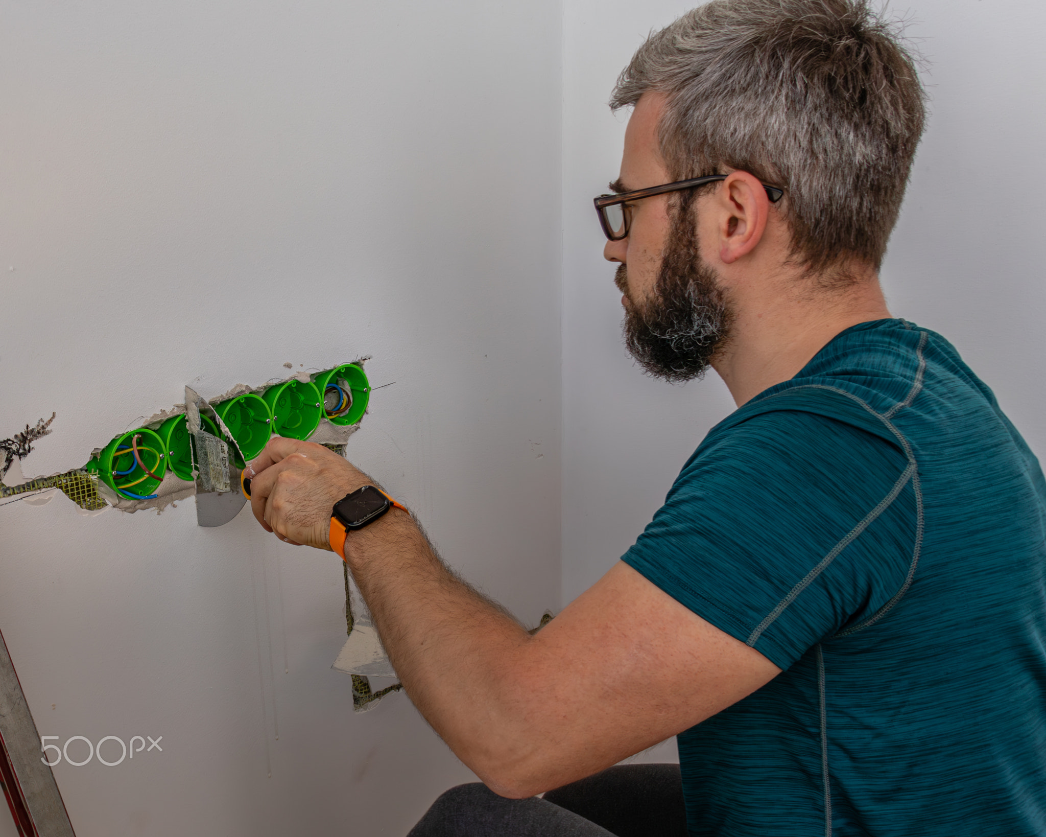 a man mounts wall sockets on plaster