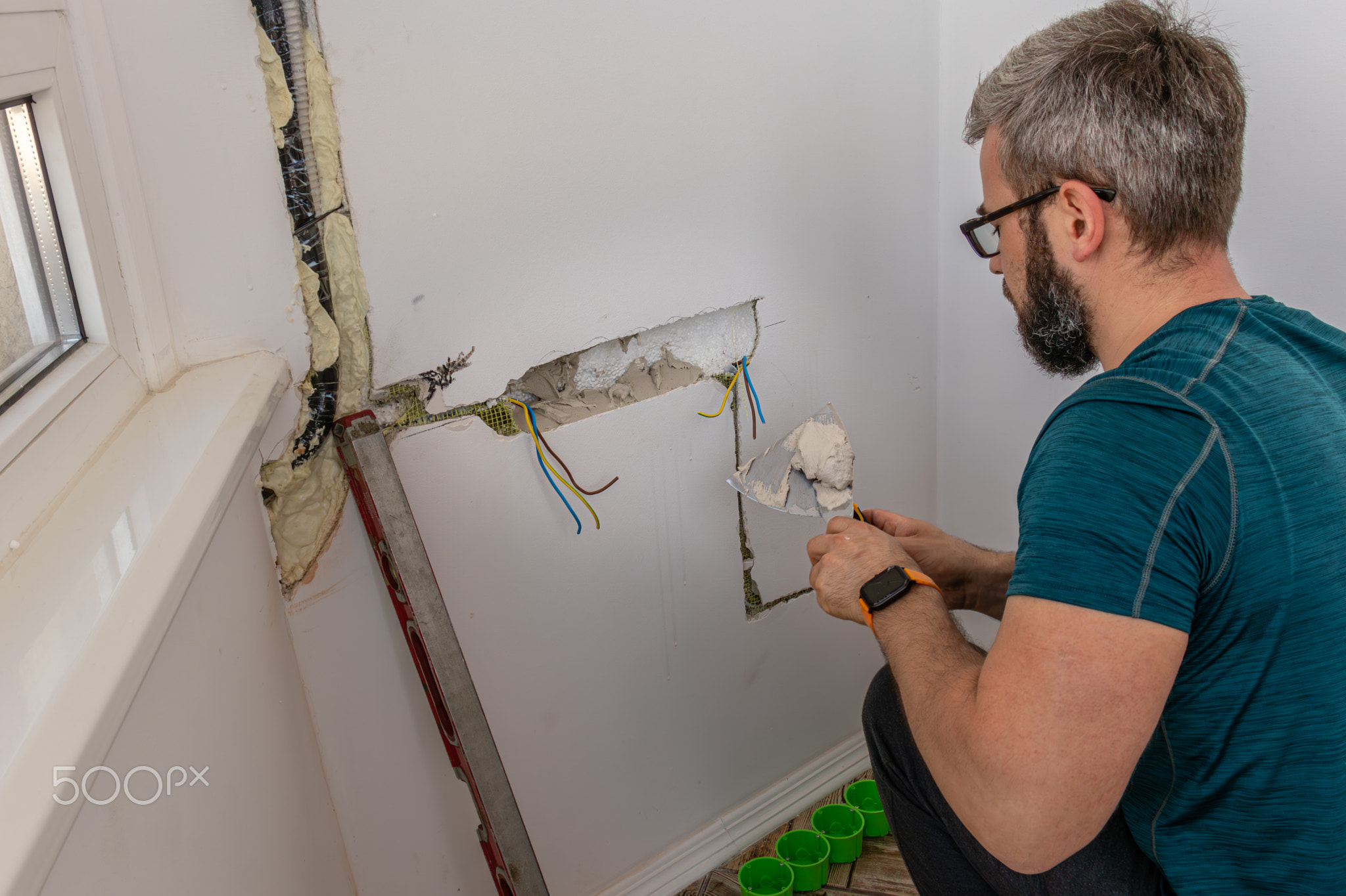 a man mounts wall sockets on plaster