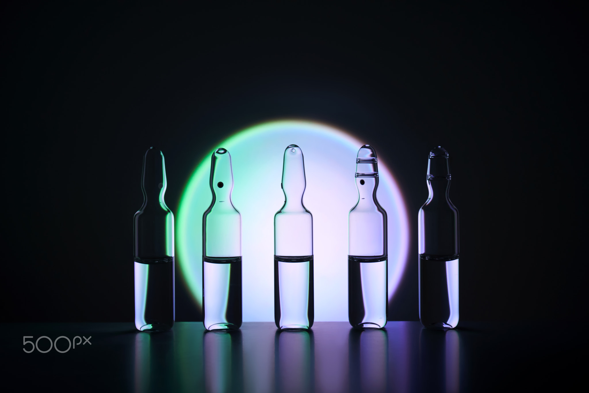 Several ampoules for injection with medicines on a blue background.