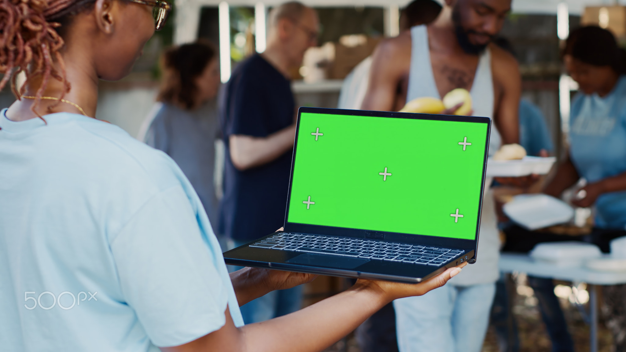 Woman holds laptop with green screen