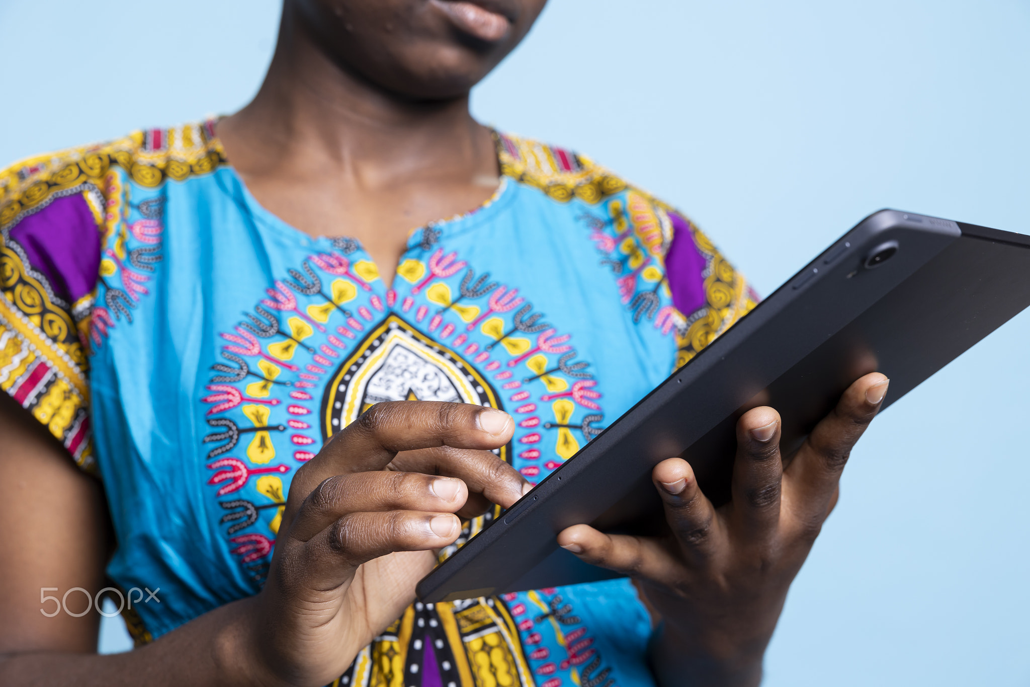Female model of African American descent uses tablet to browse social