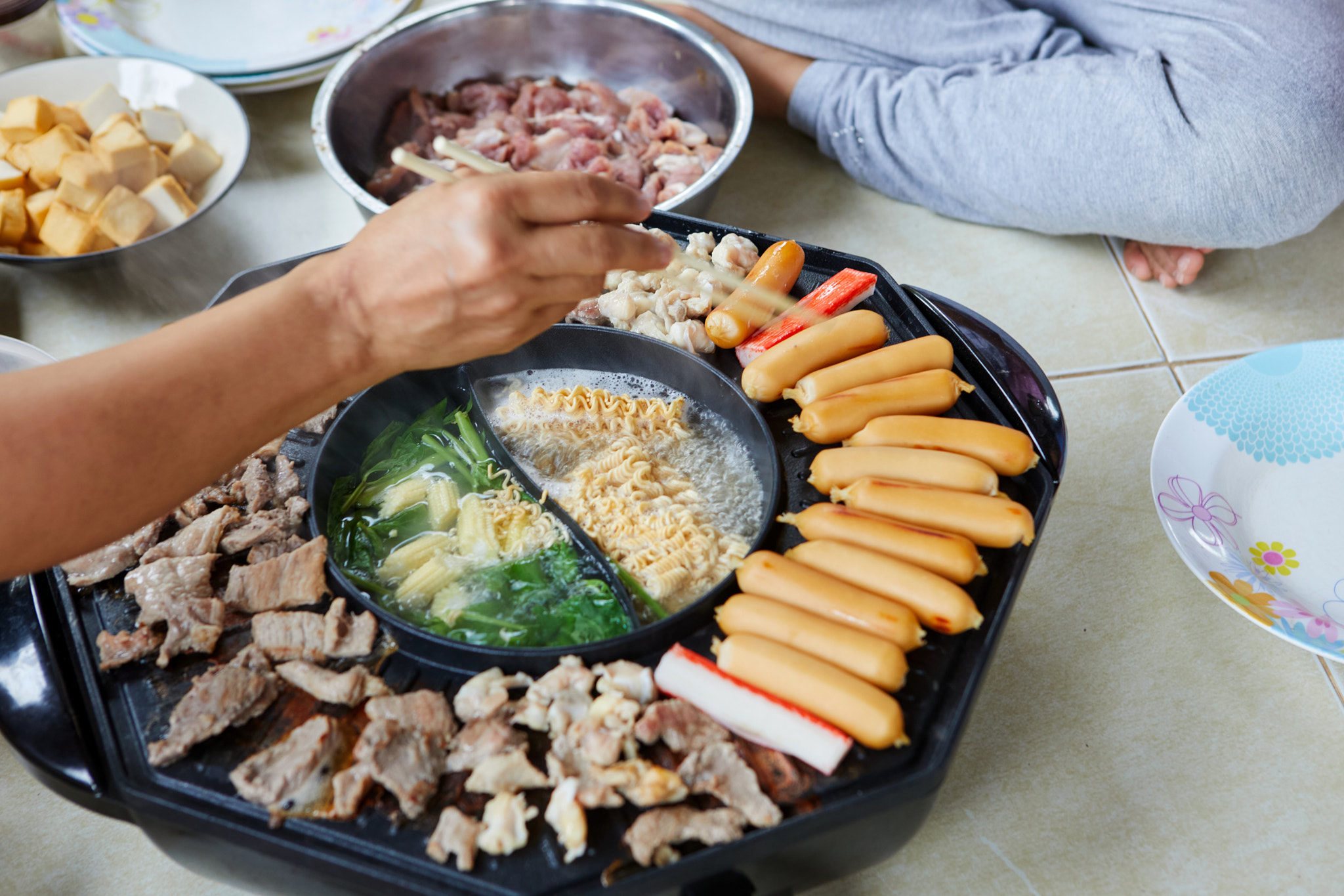 cropped view of people eating meat on electric pan together