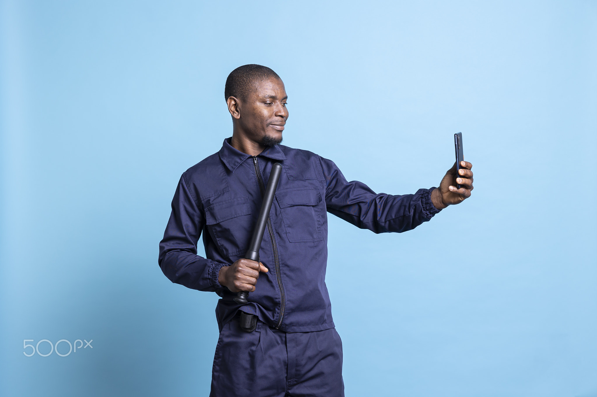 Smiling security agent taking photos with his baton on camera