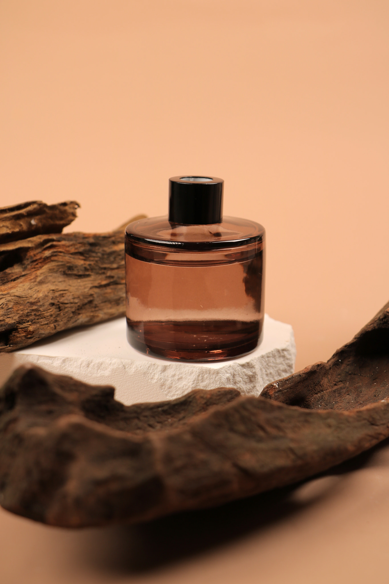 Amber Glass Bottle on Stone with Natural Wood Accen