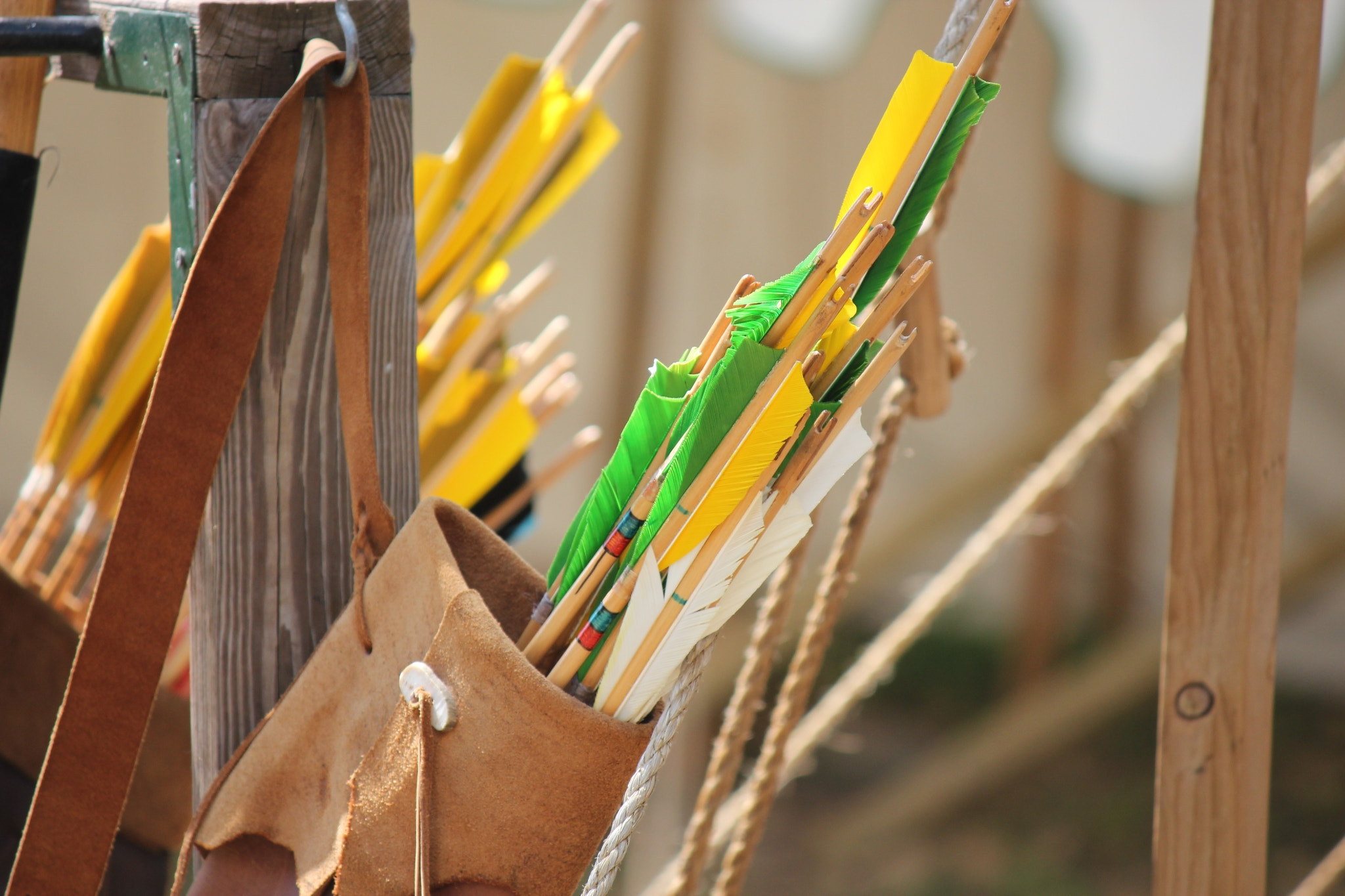 A Leather Quiver Full of Colorful Arrows Hanging on a Wooden Post