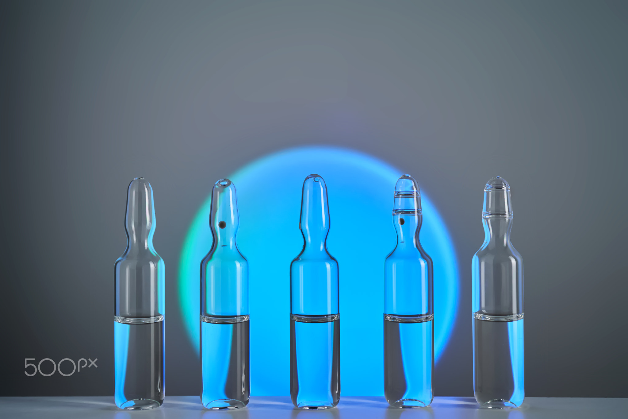 Several ampoules for injection with medicines on a blue background.