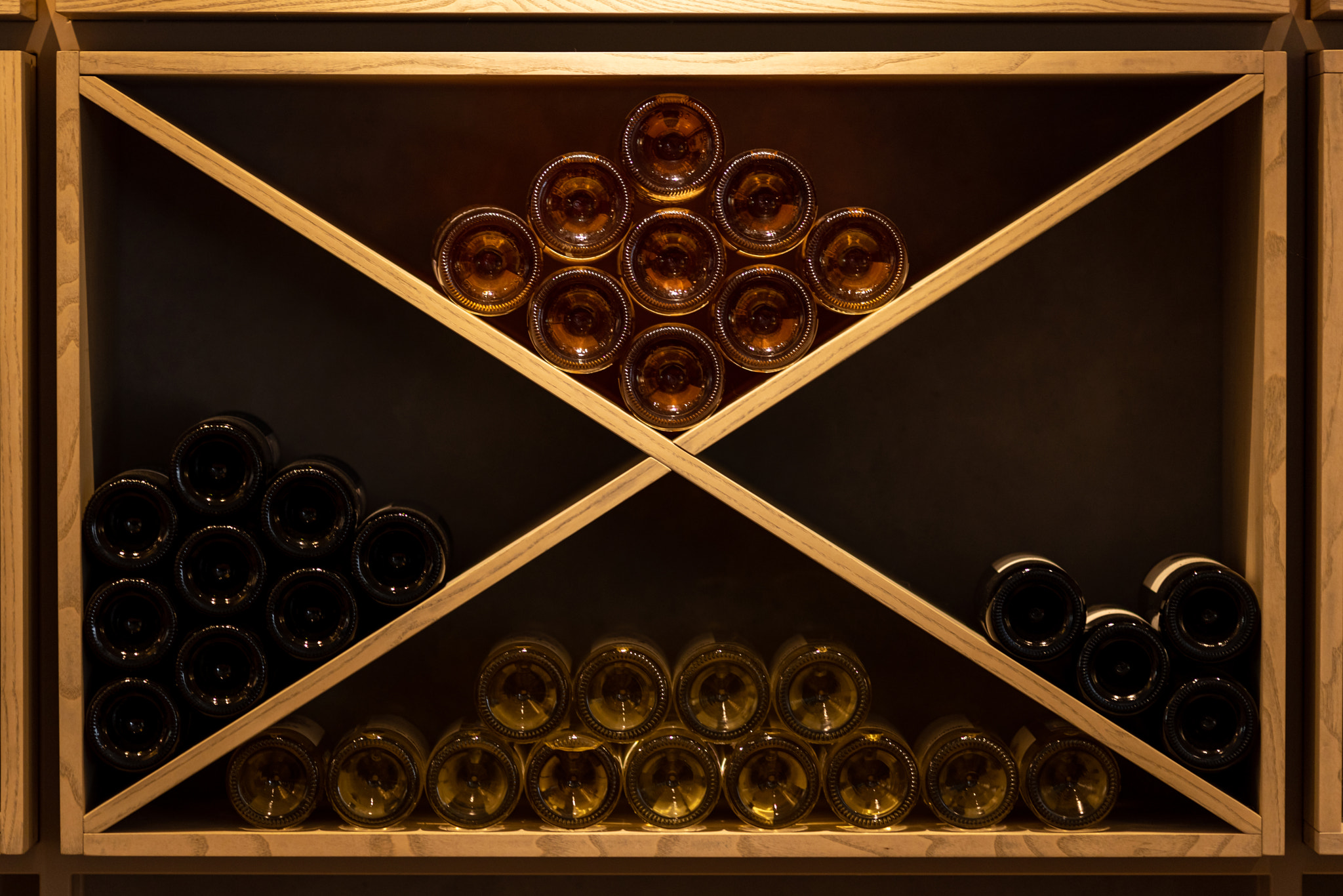 Light wood wine rack with bottles, white, pink, orange, red wine