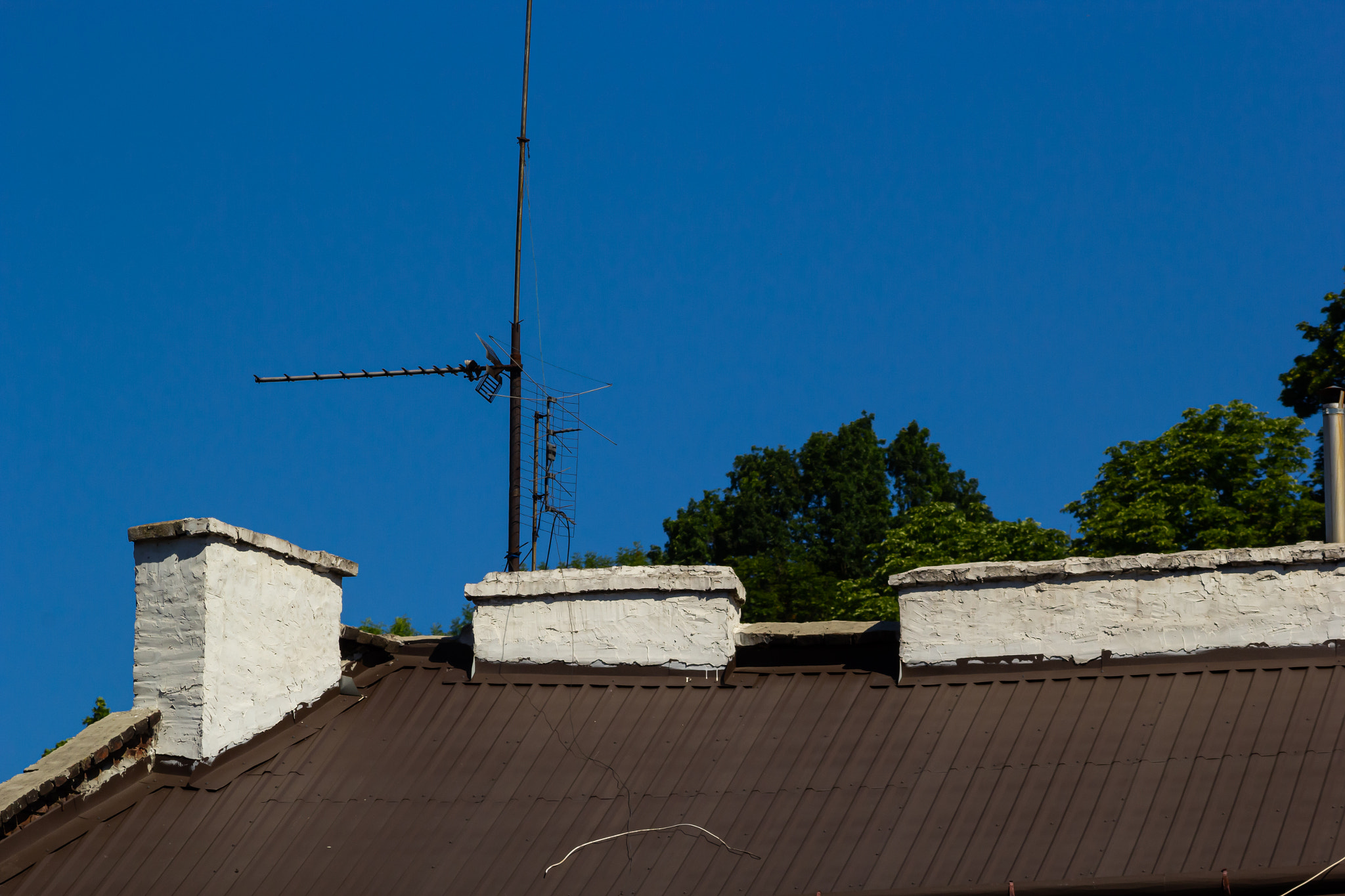 Metal roof of a detached house and chimney against the sky, metal roof tiles, gutters