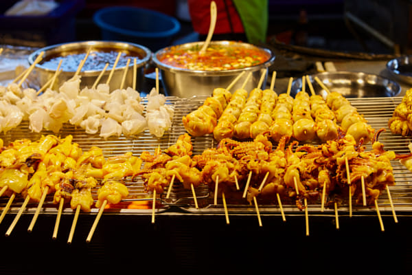 Close-up view of skewer squid on cooling rack at street market by Anucha Muphasa on 500px.com