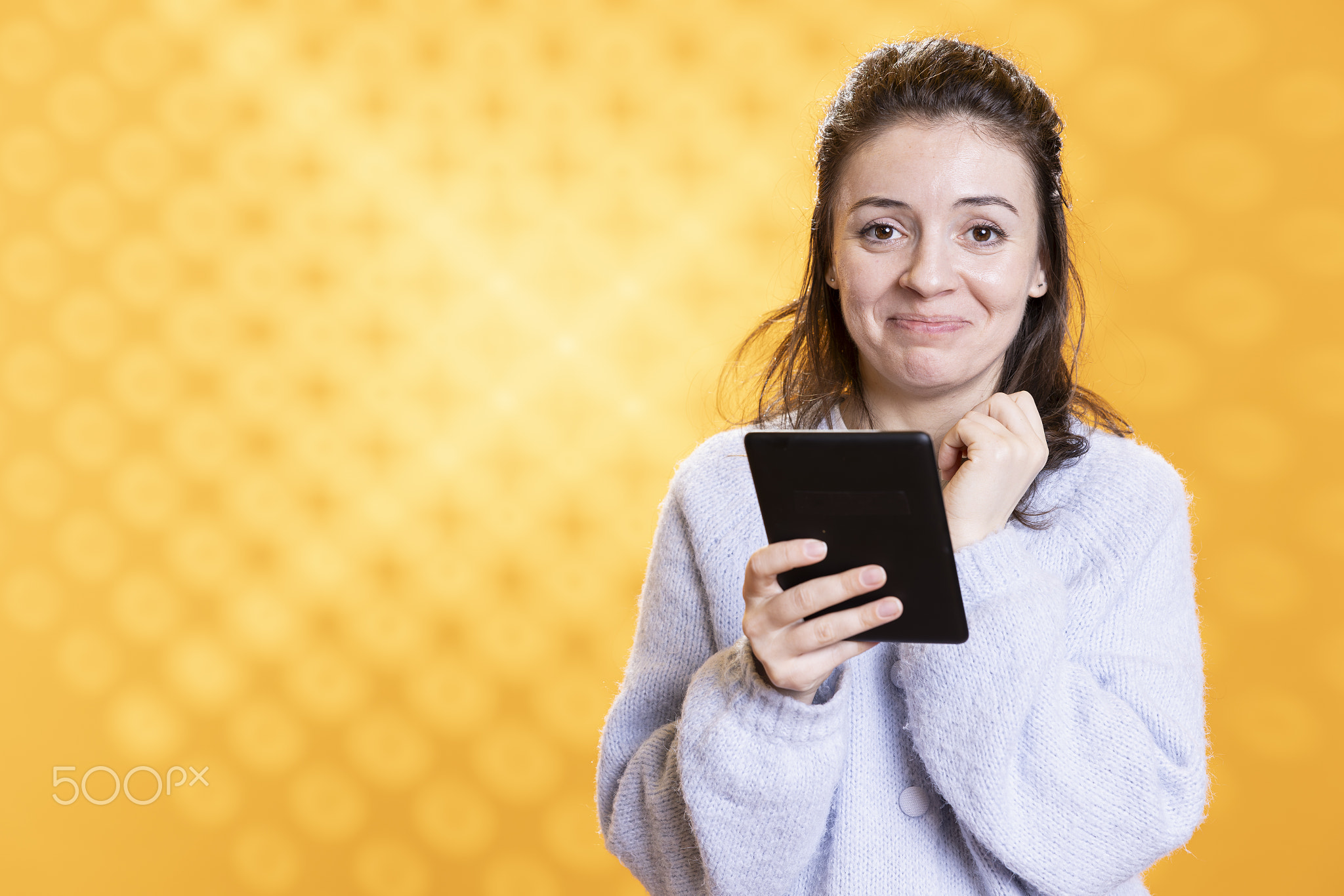 Woman warmed by touching ebook on ereader, studio background