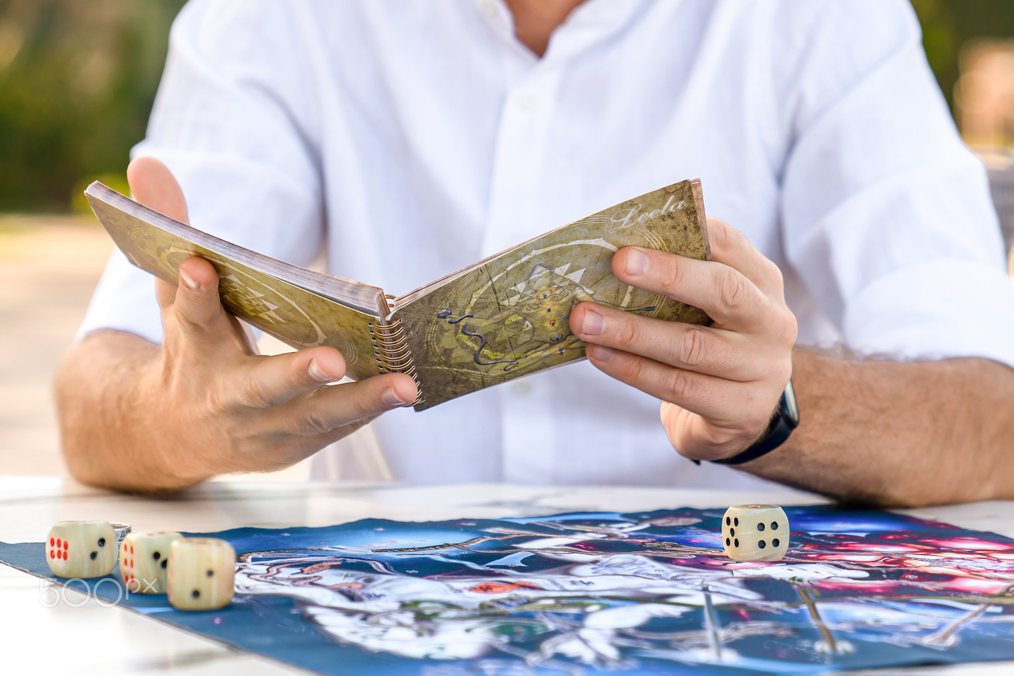 Instructions for Game of Leela: Man Holds Book in Hands, Close-Up