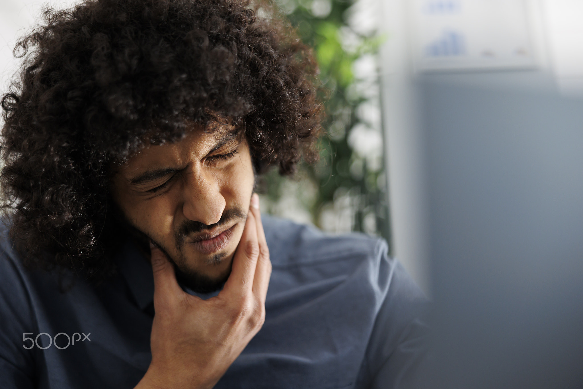 Arab entrepreneur suffering from toothache while having online meeting
