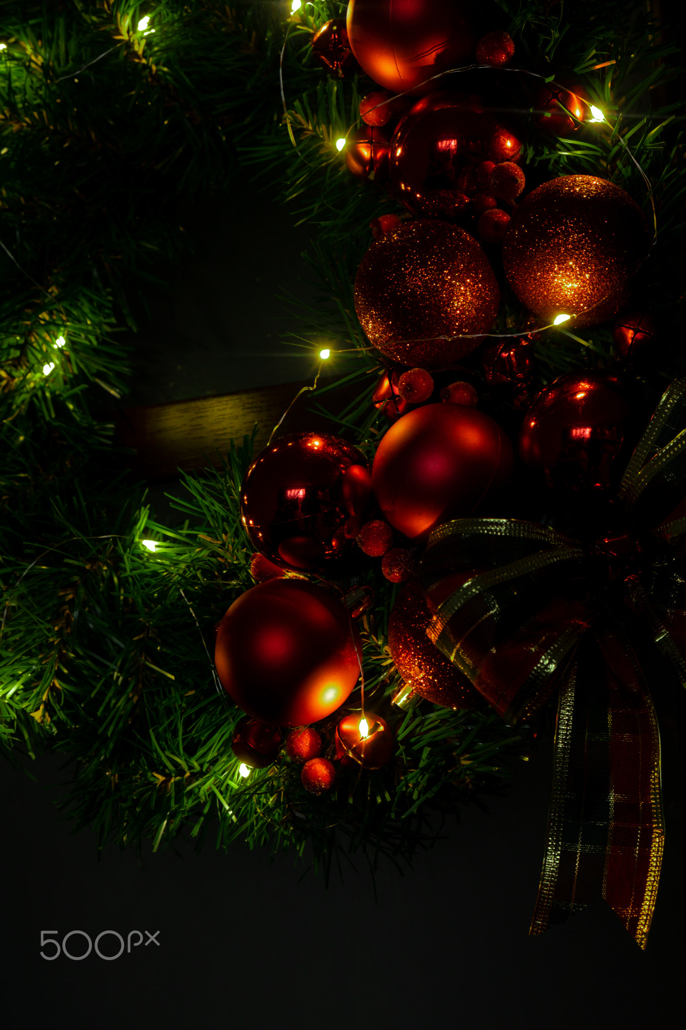 DIY process of woman making Christmas arrangement with decor in red