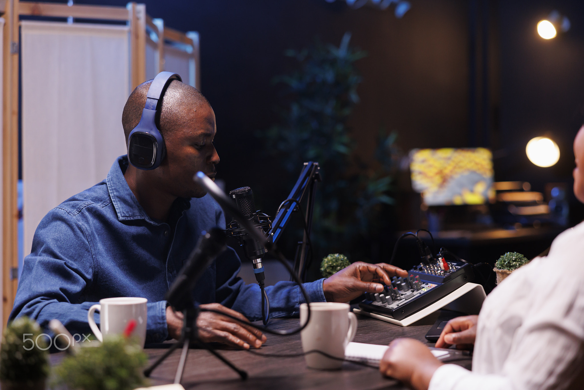 Black man using audio mixer and mic setup