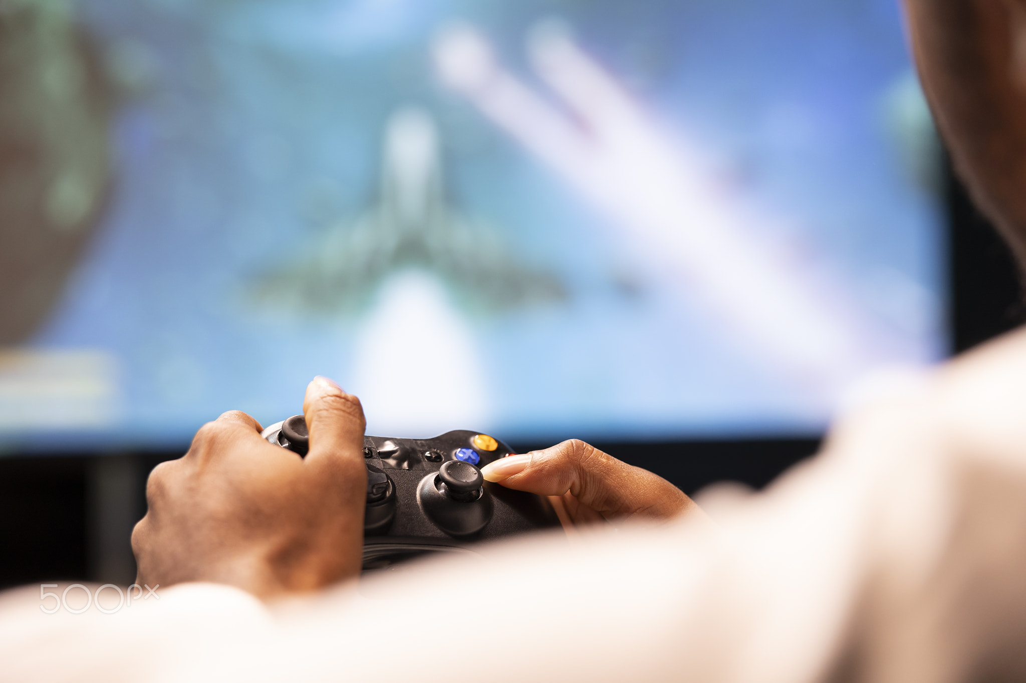 Close up of controller held in gamer hands playing classic arcade
