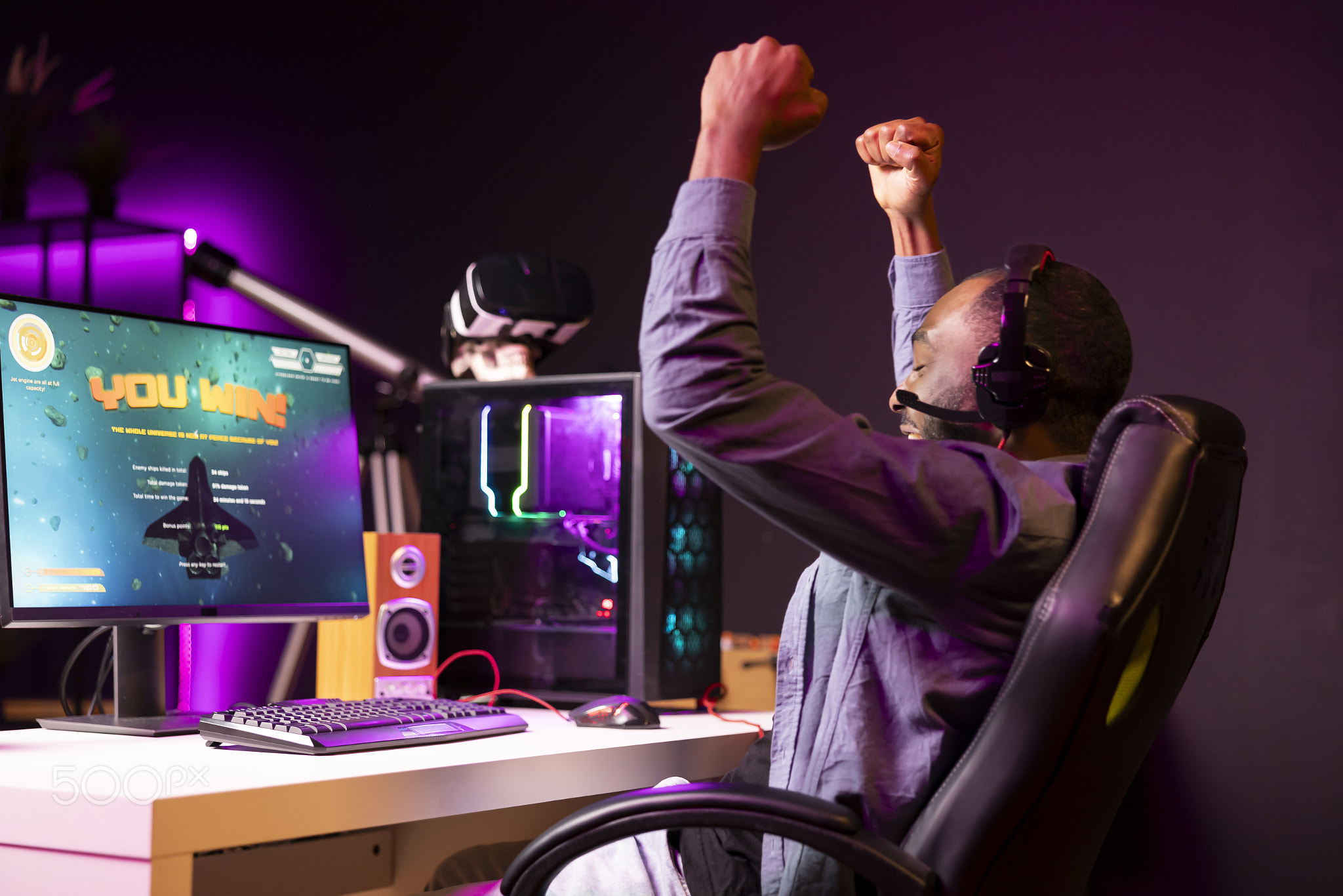 Joyous gamer throwing fists in air from excitement after winning SF