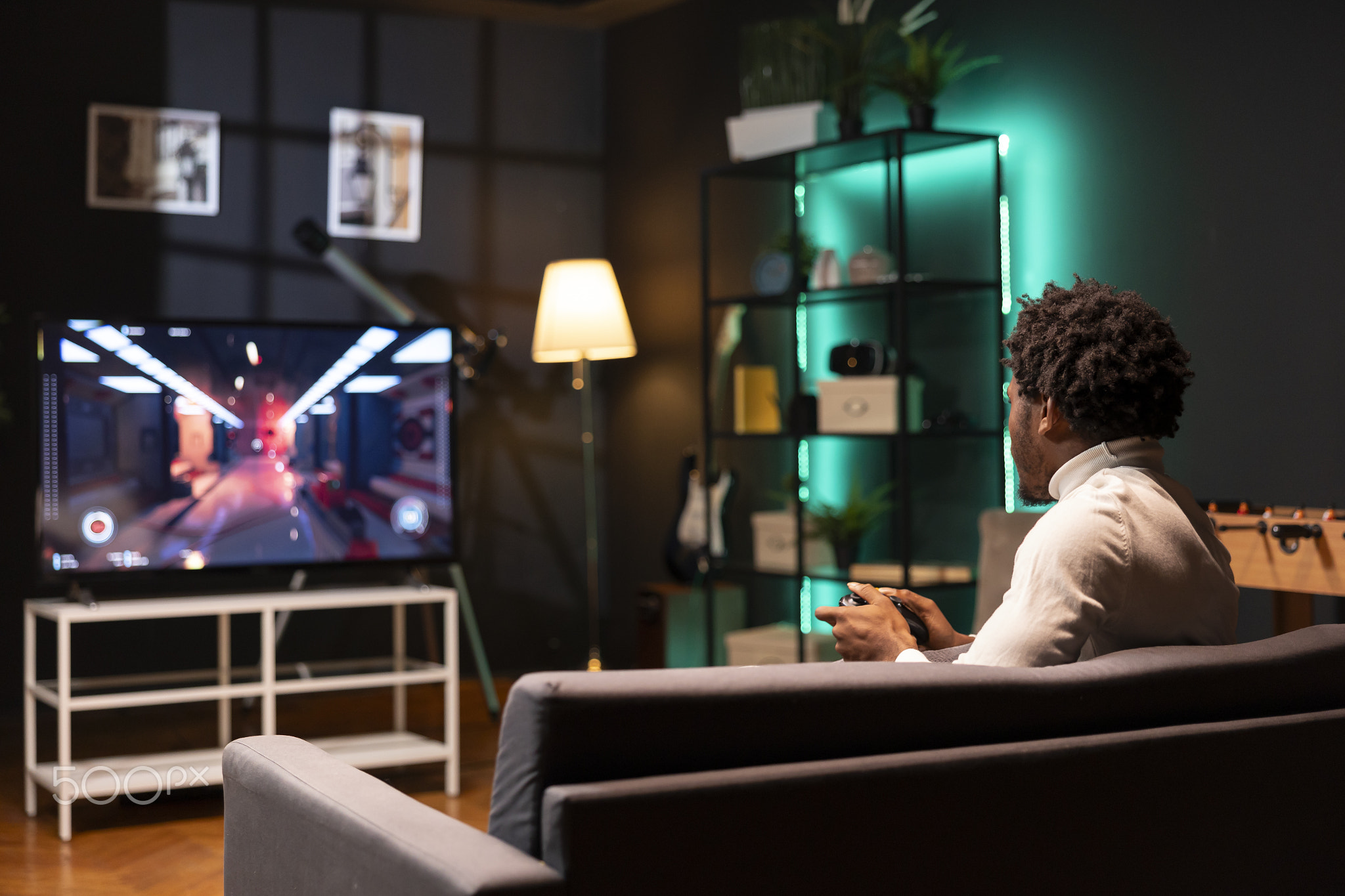 Gamer enjoying high quality FPS game, shooting enemies using gamepad