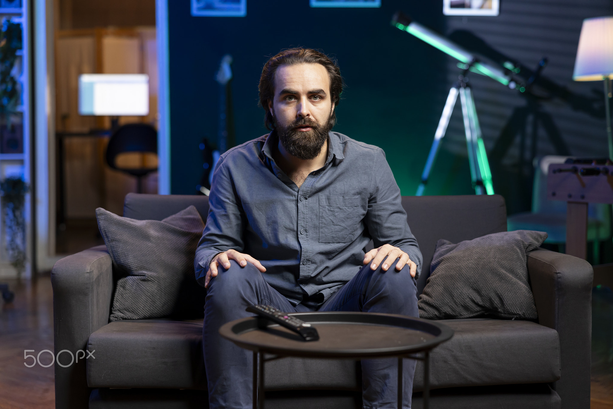 Portrait of man in apartment looking at entertaining football