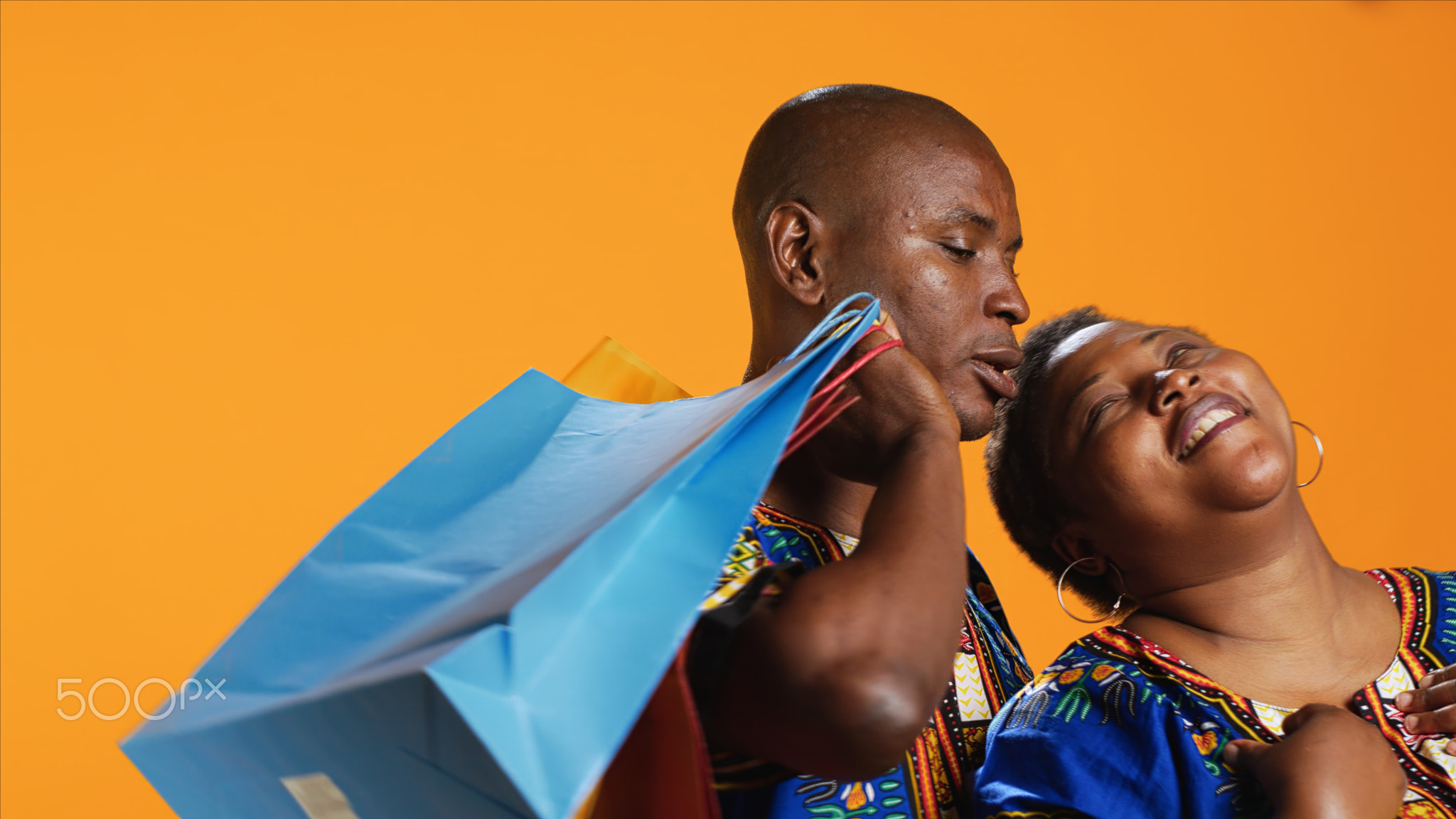 Tired husband carrying shopping bags for his wife