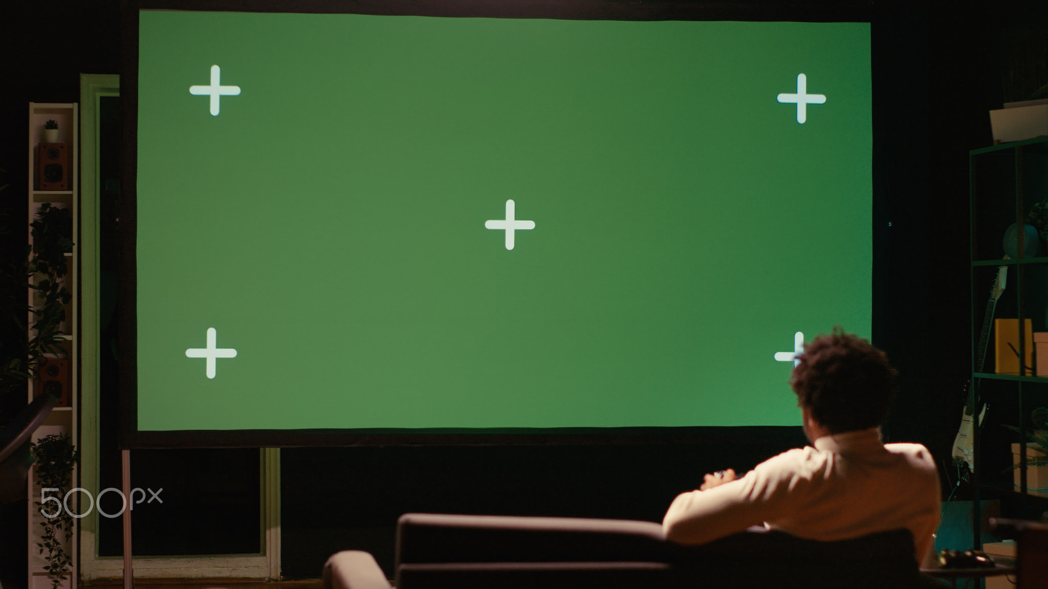 Man playing singleplayer videogames on green screen TV in cozy living