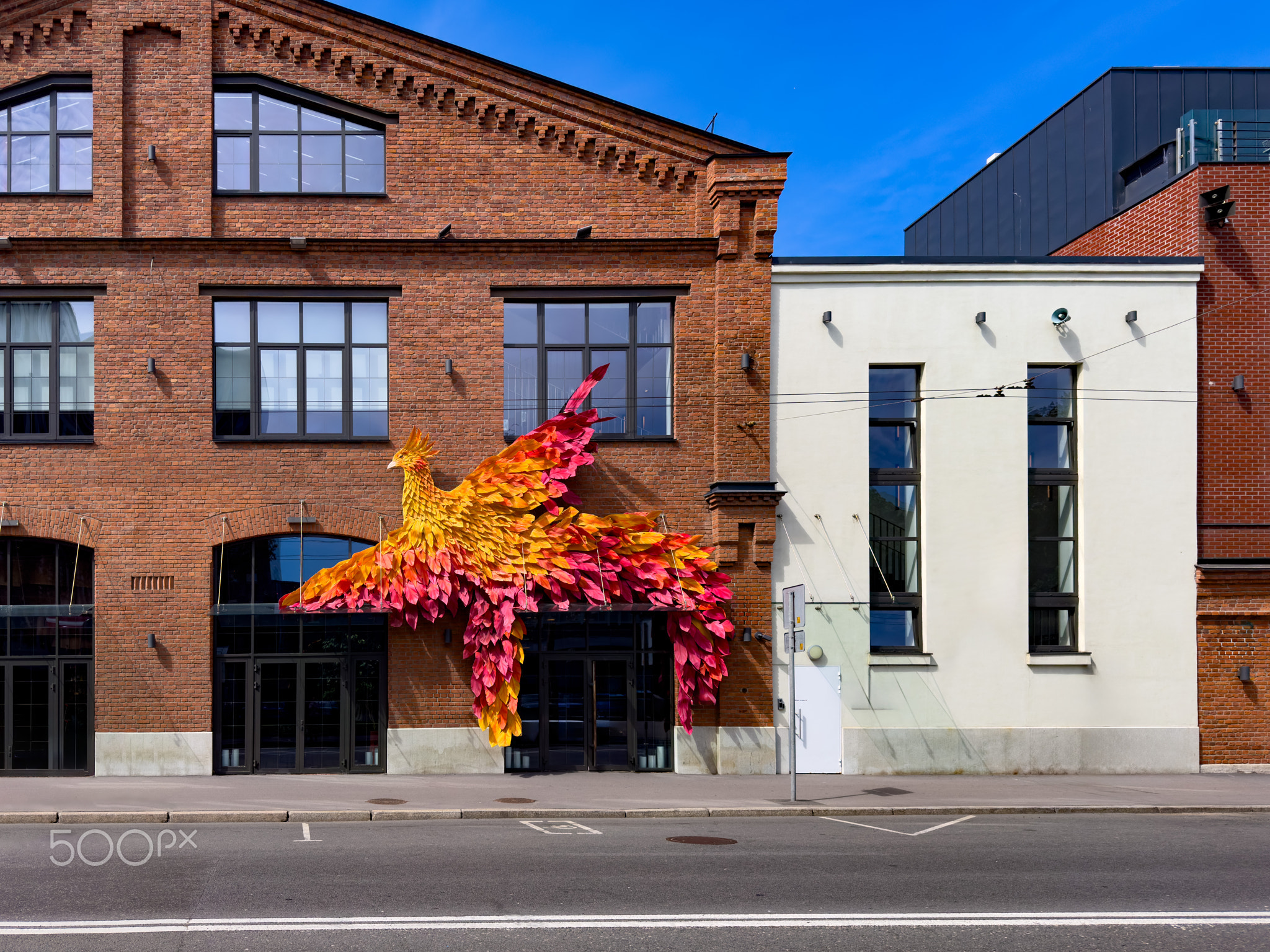 Colorful Phoenix Sculpture on Brick Building Facade