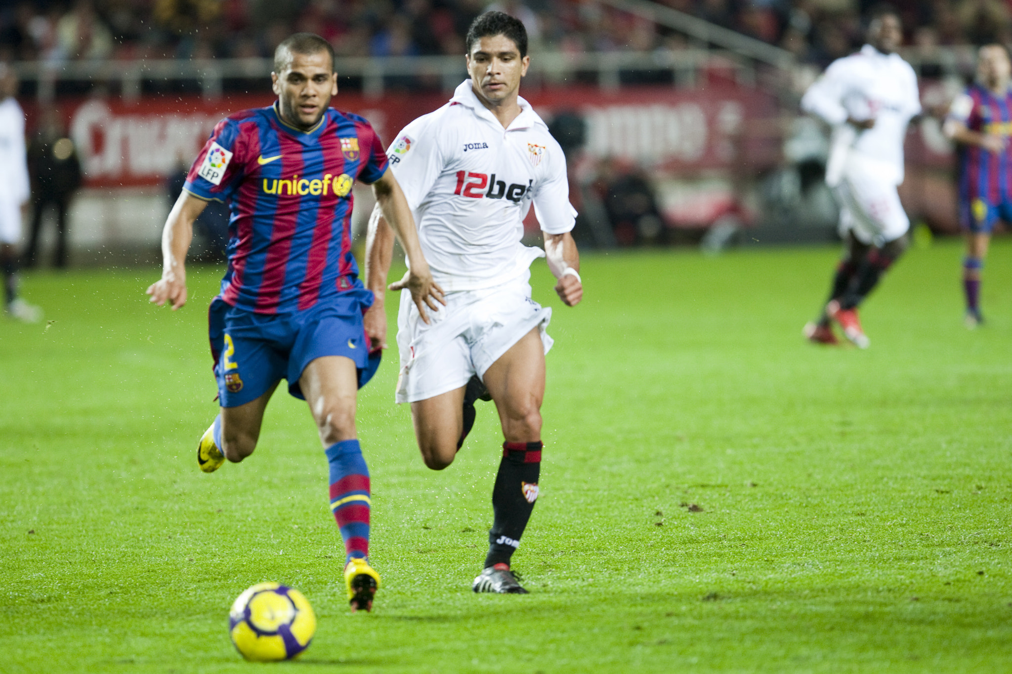 Daniel Alves with the ball pursued by Renato. Spanish Cup game between Sevilla FC and FC Barcelona,